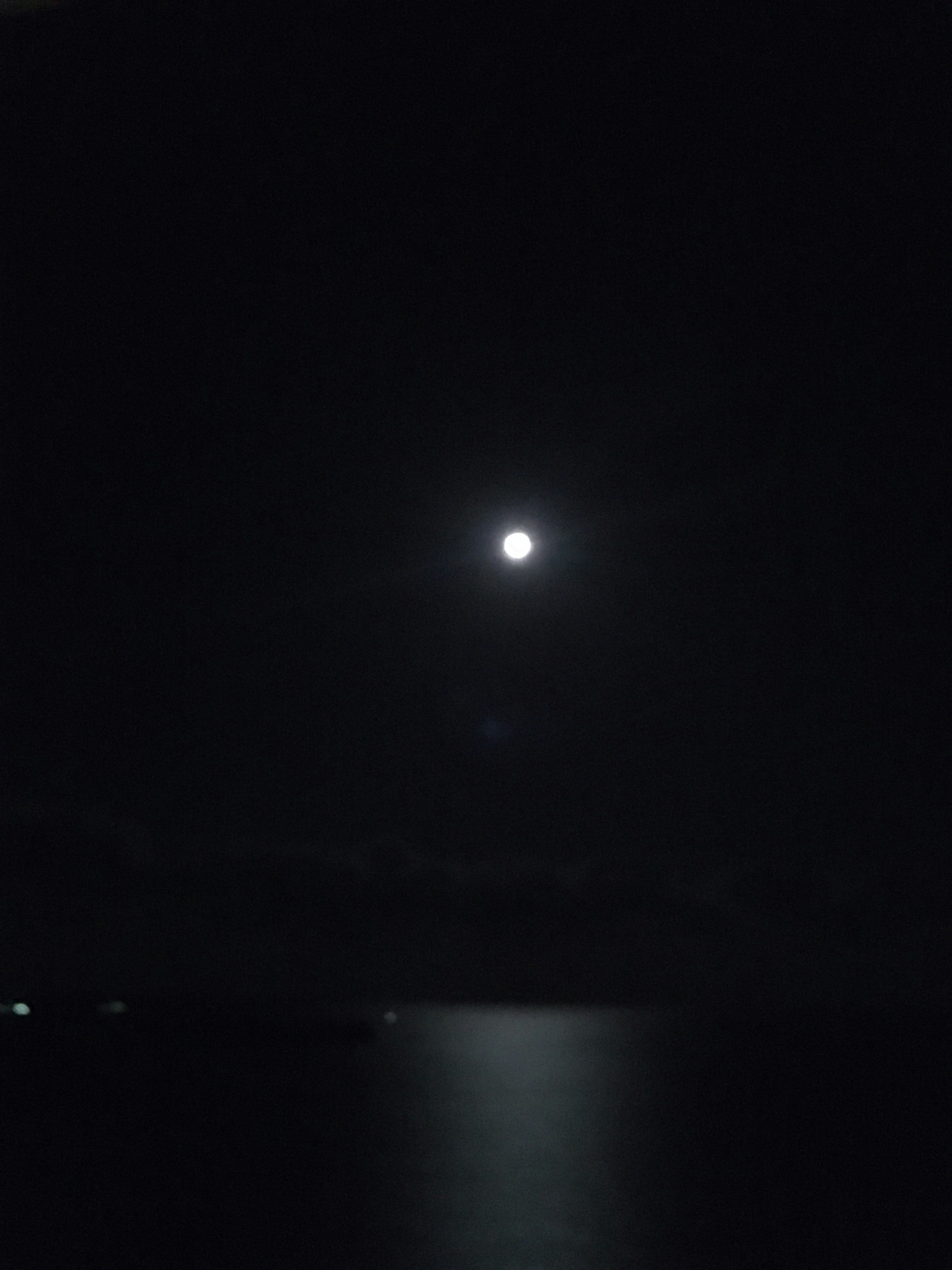 夜空に輝く満月とその反射が水面に映る美しい風景