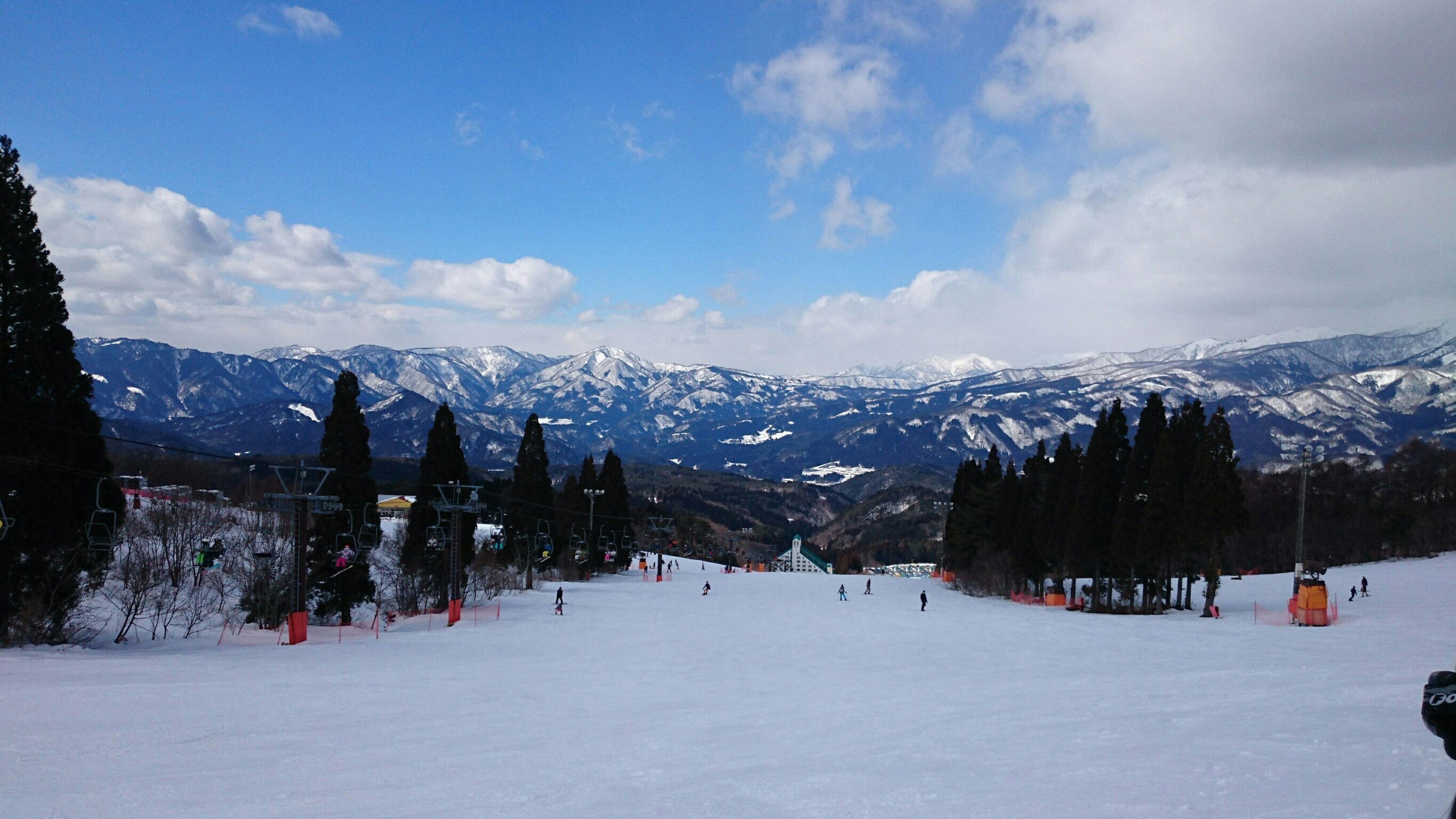 Wide view of a snow-covered ski resort with blue sky