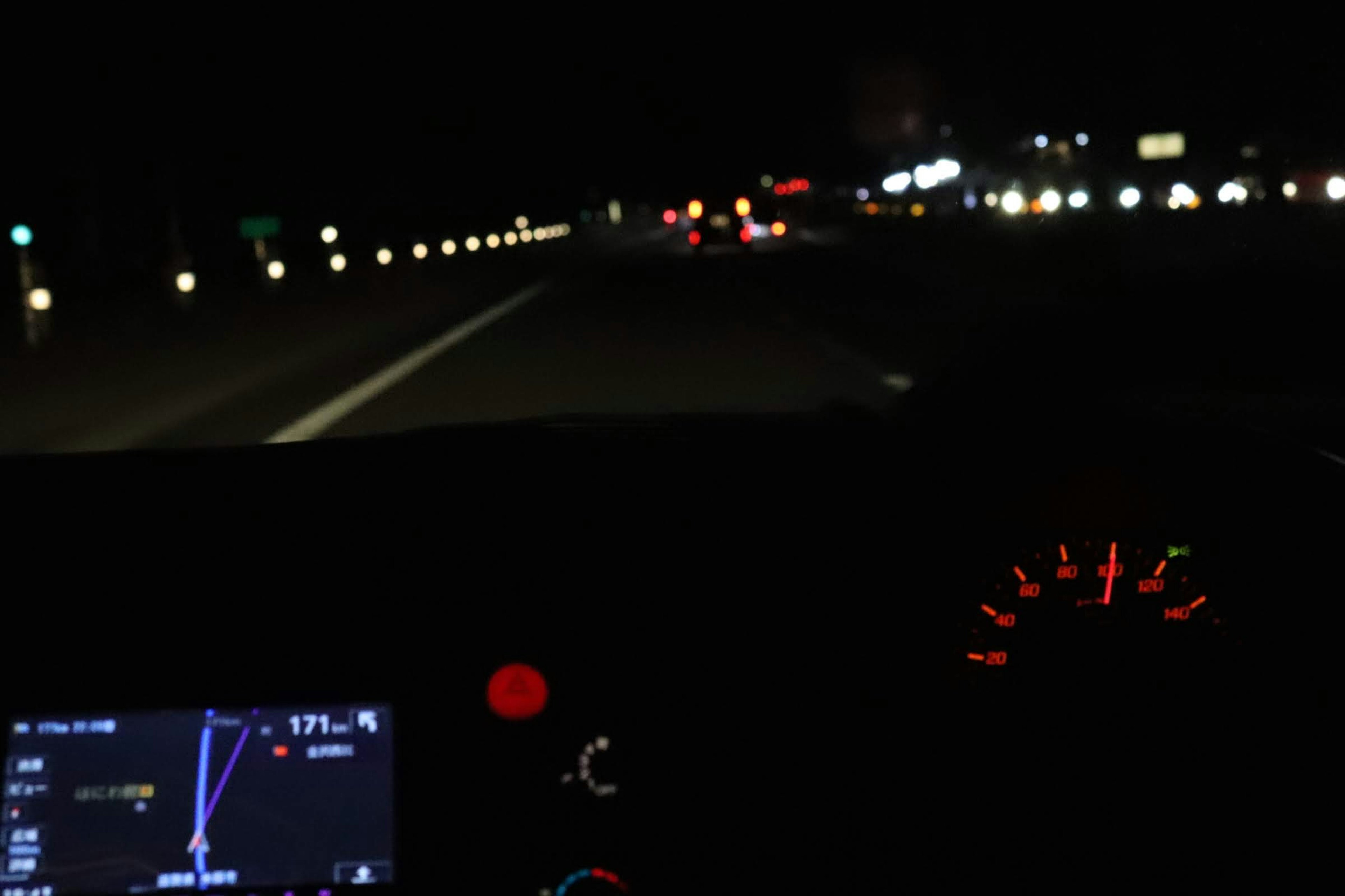 Interior view of a car driving on a highway at night with navigation screen