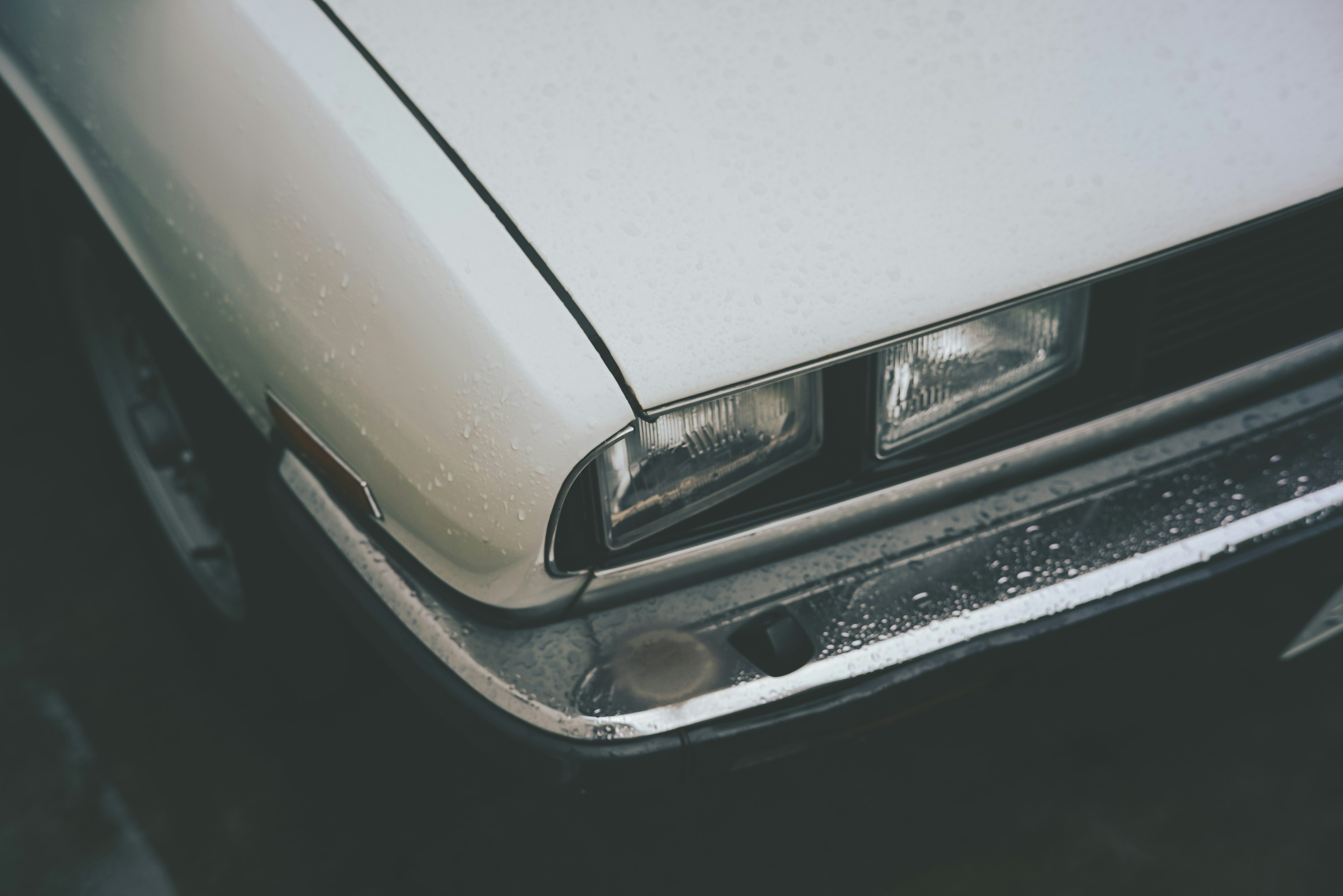 Gros plan sur l'avant d'une voiture blanche avec des phares et des lignes de carrosserie