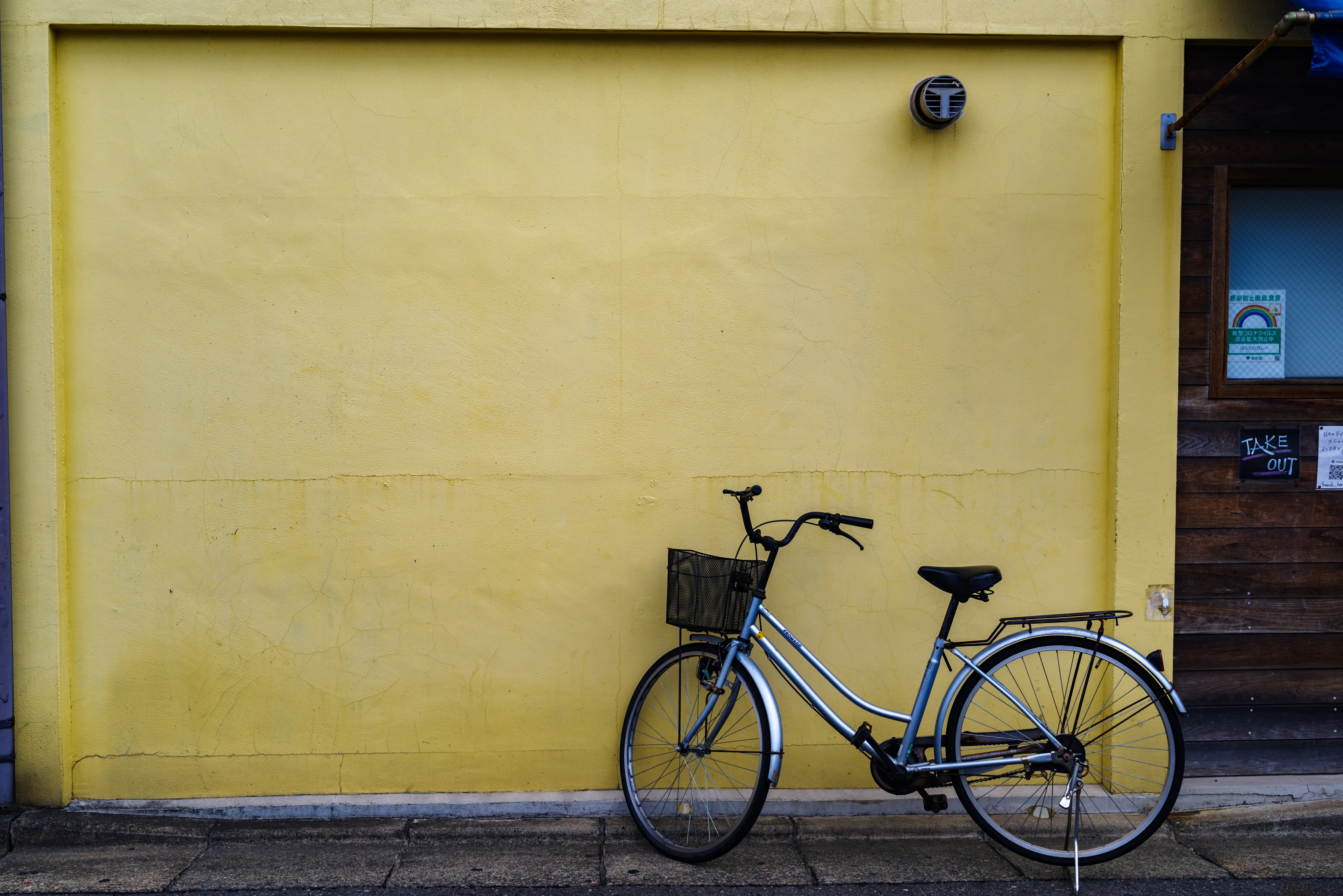 Bicycle leaning against a yellow wall