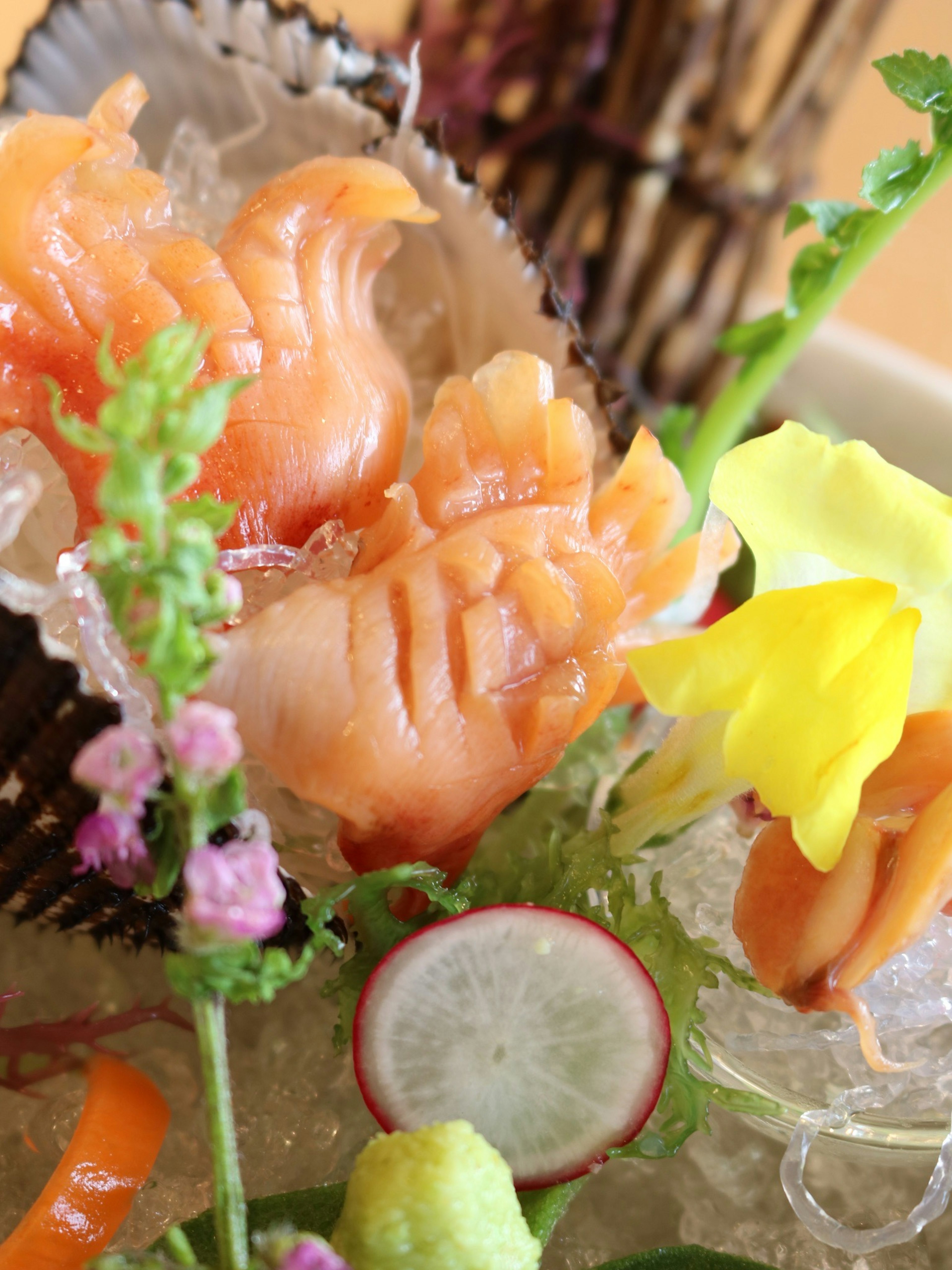 Sashimi joliment présenté avec des légumes et des fleurs colorées