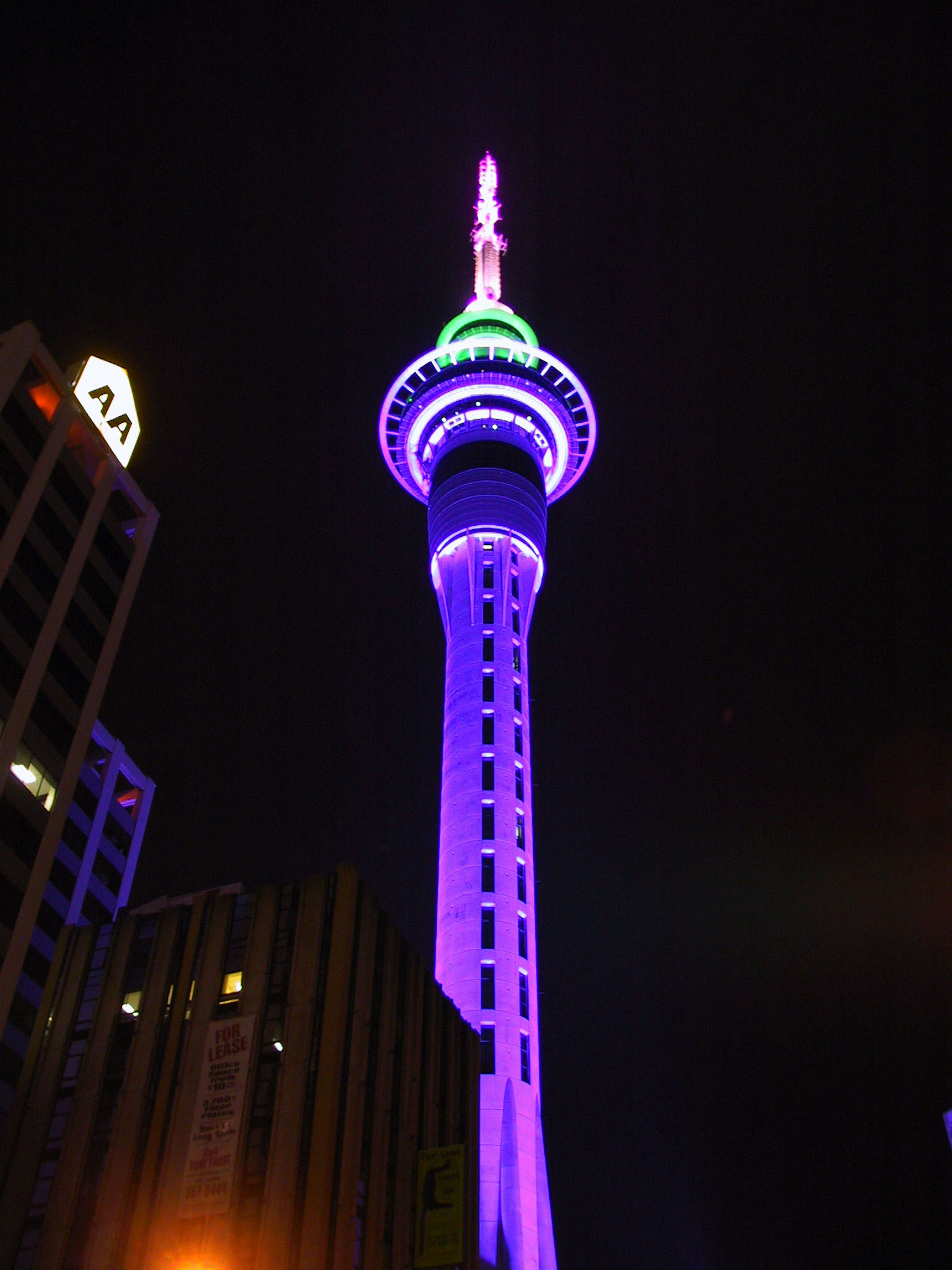 Sky Tower iluminada con luz púrpura por la noche