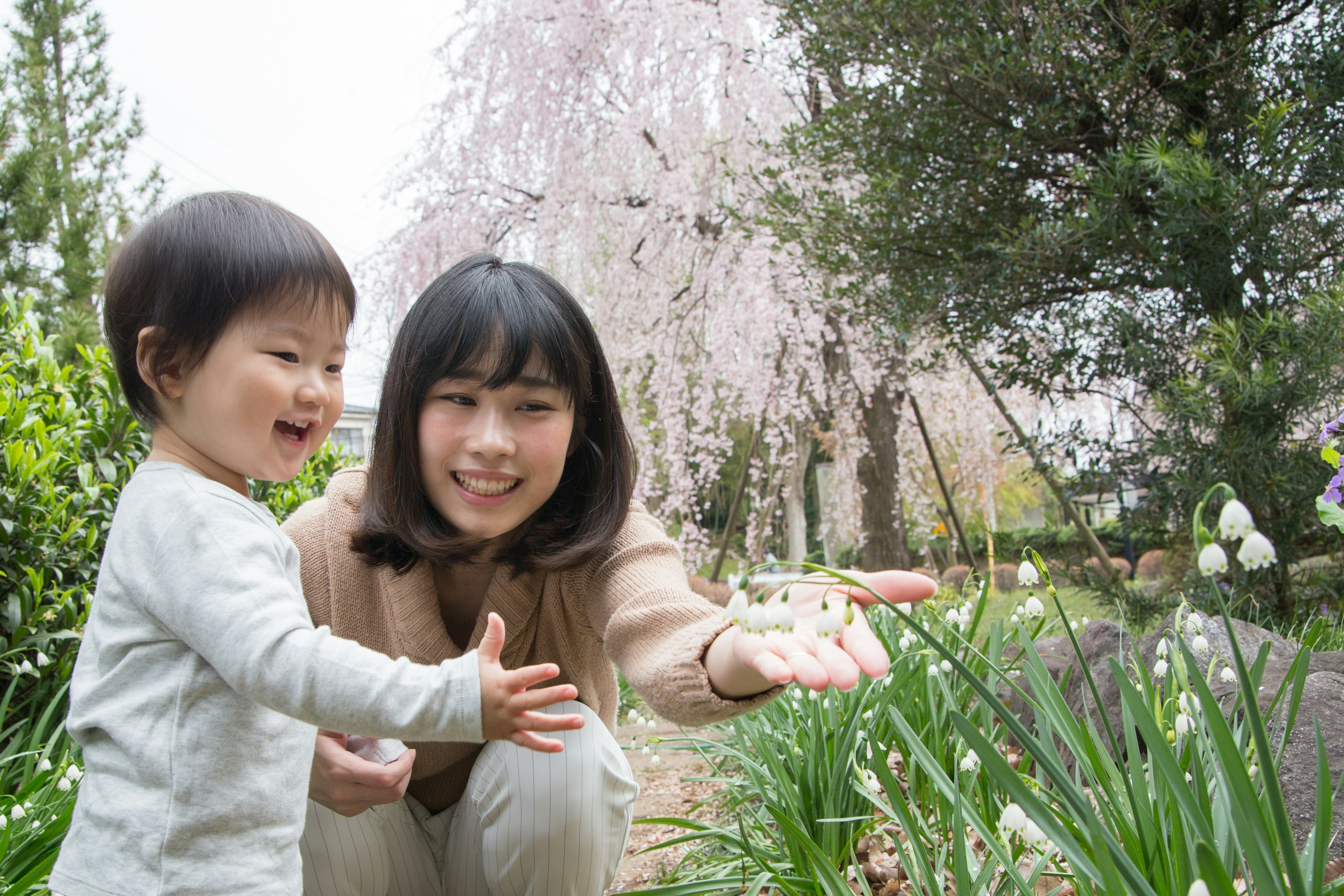 Una madre e un bambino che godono dei fiori in un giardino primaverile