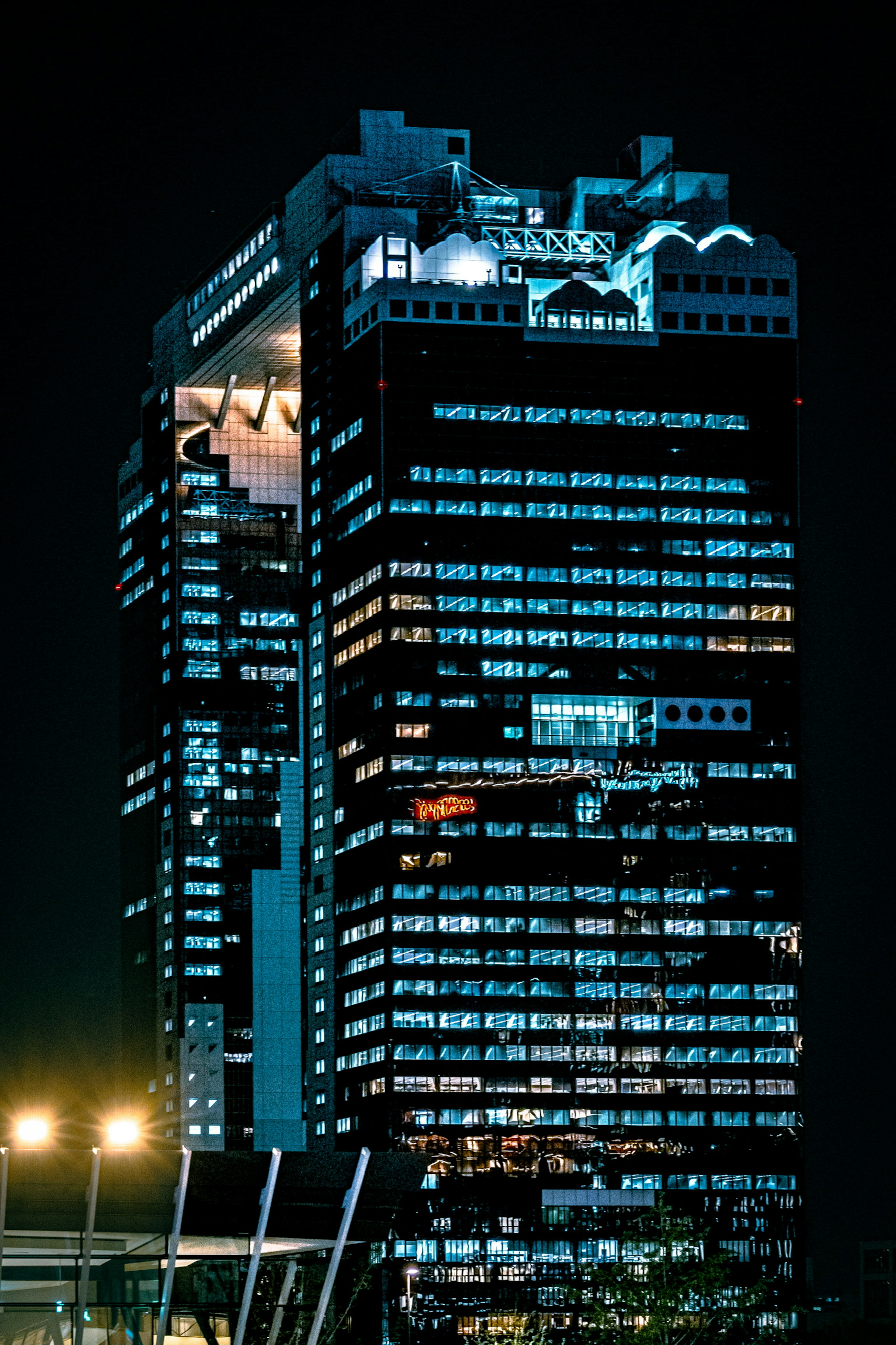 Vue nocturne d'un gratte-ciel moderne illuminé dans un cadre urbain