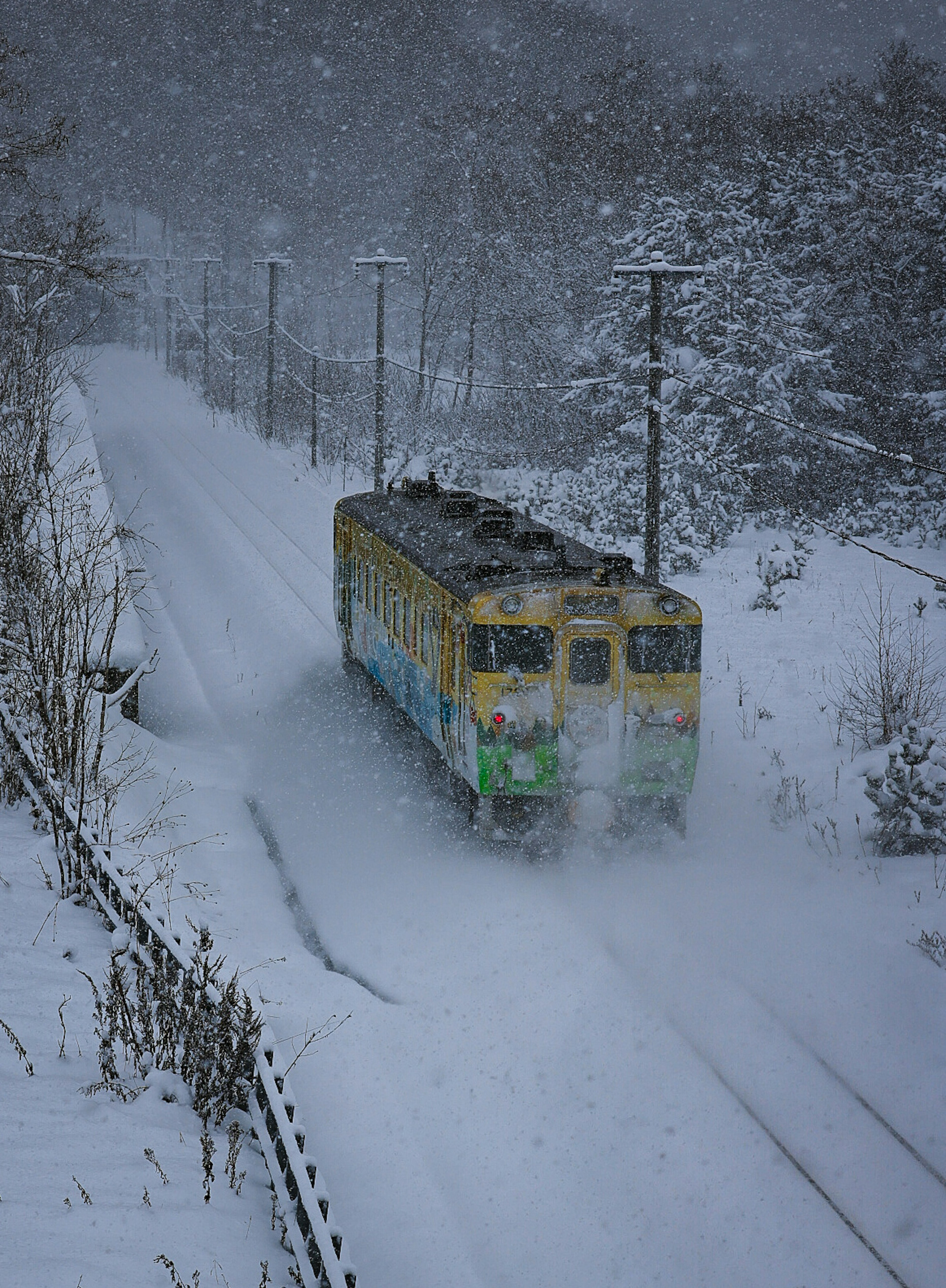 雪の中を走る列車の後ろ姿と白い風景