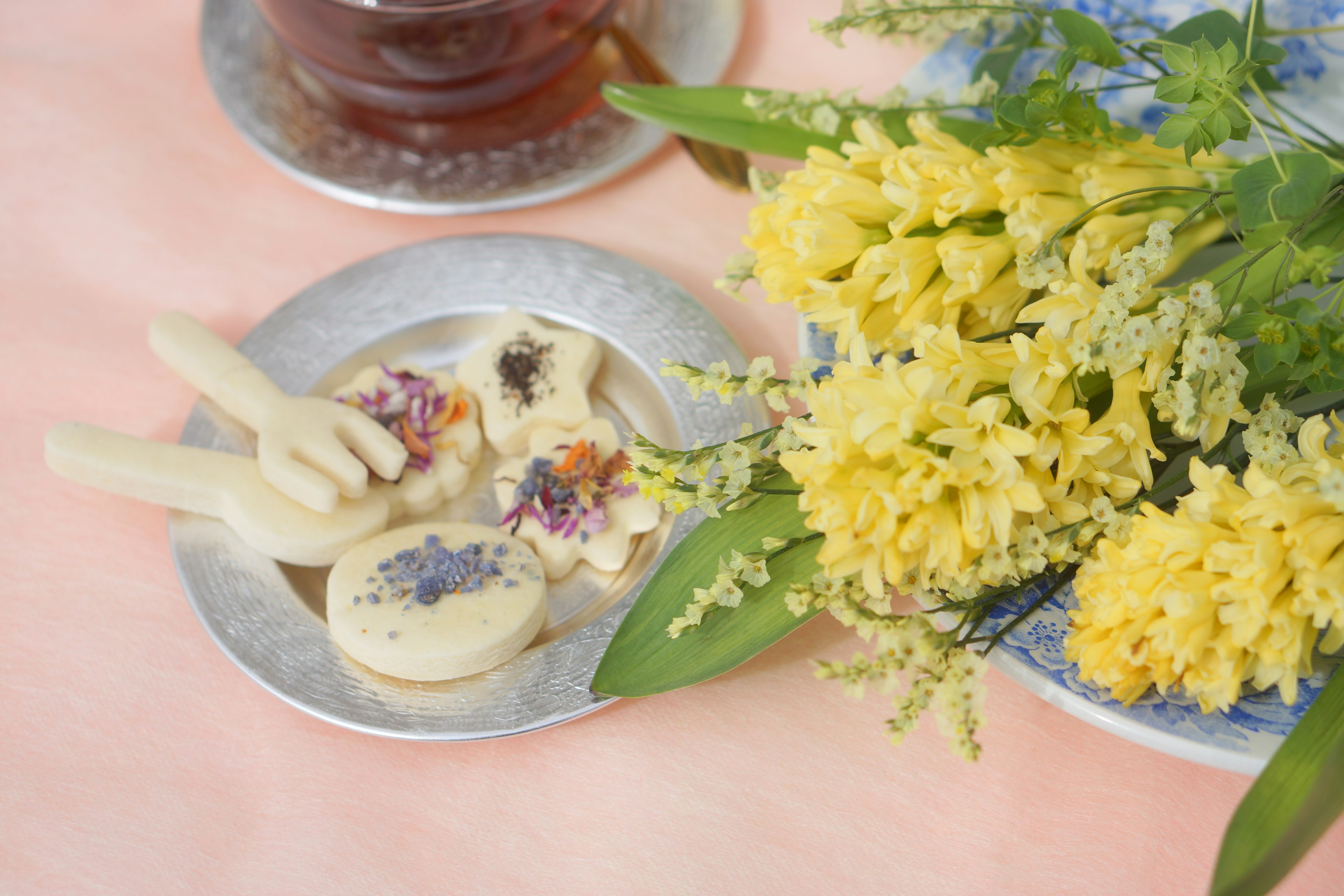 お茶と花が並ぶテーブルの上にあるお菓子の皿