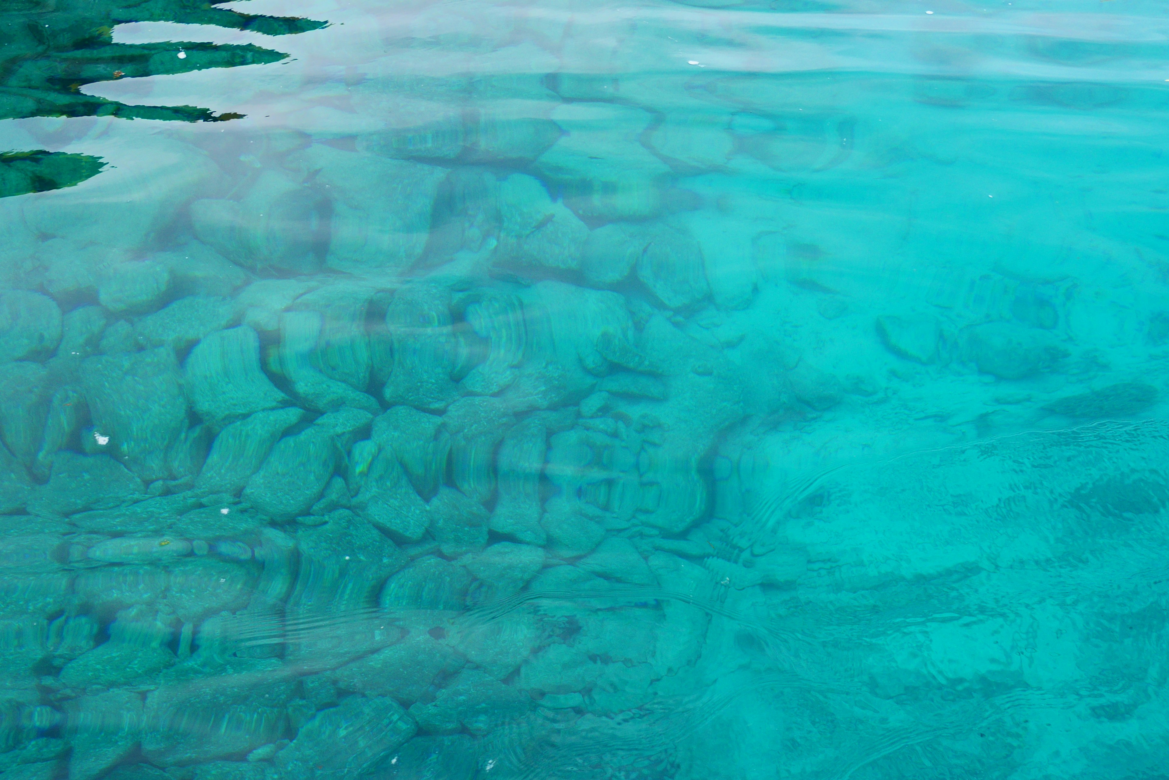 Acqua turchese trasparente che rivela rocce e motivi sottomarini