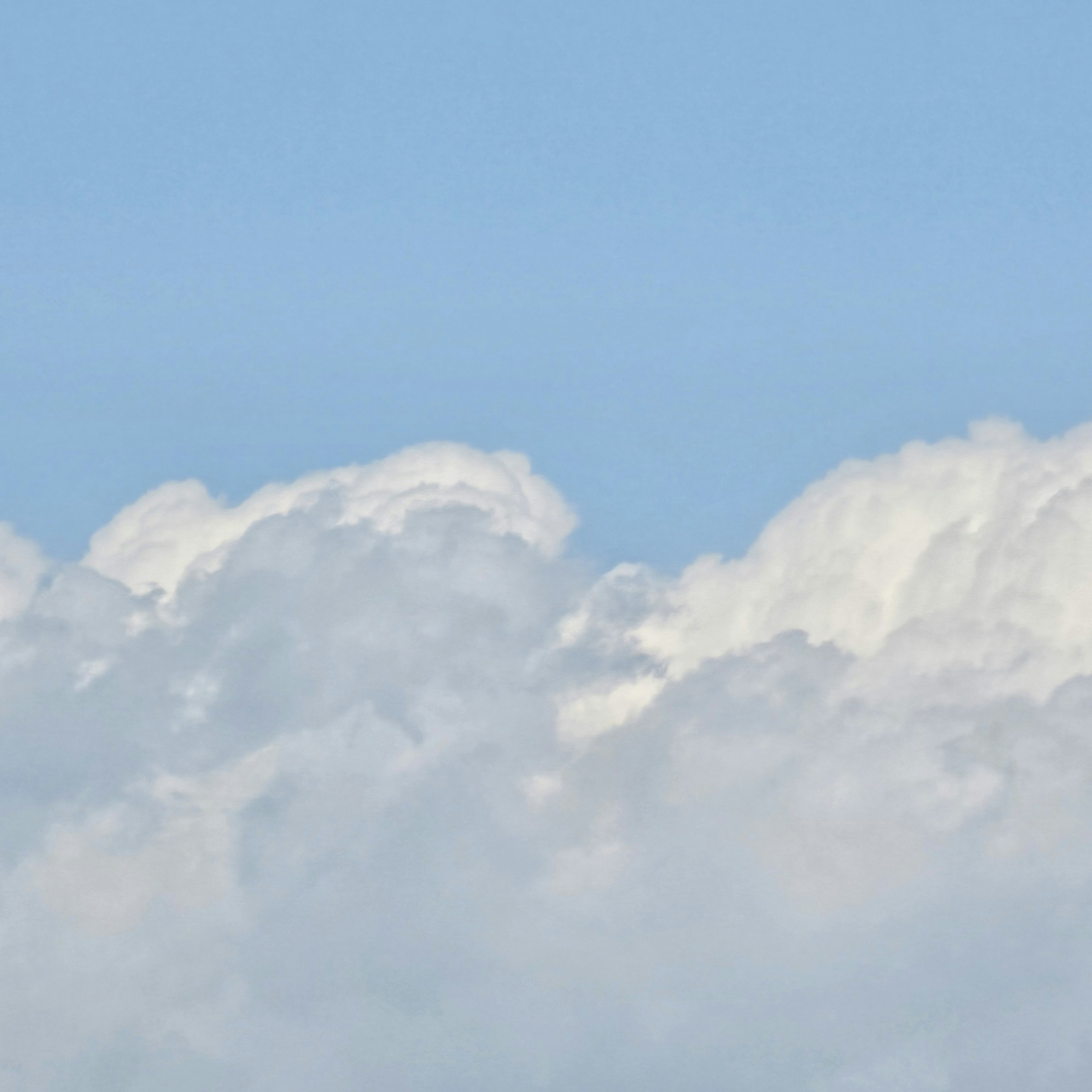 A view of white clouds floating in a blue sky