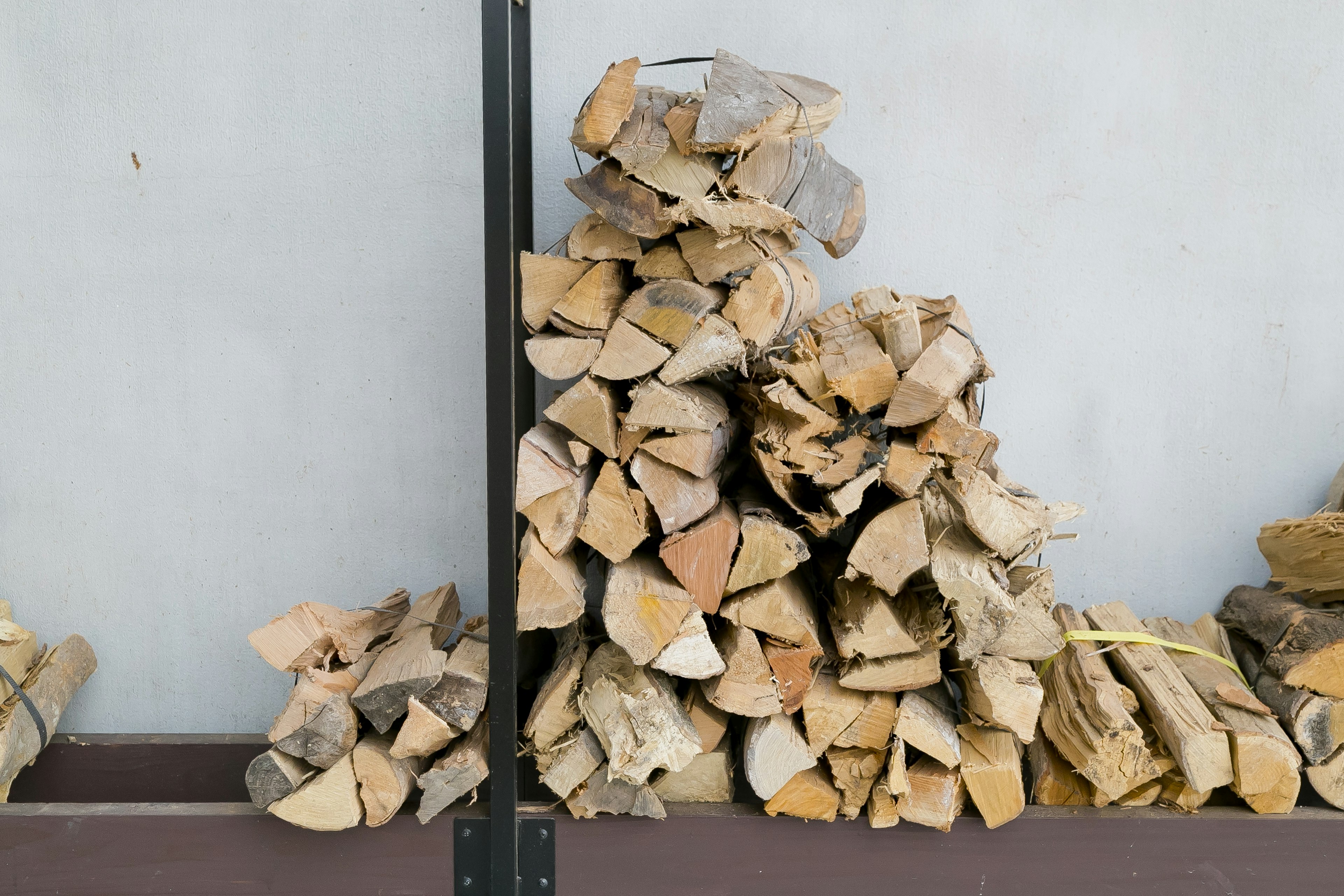 Stack of firewood neatly arranged against a wall