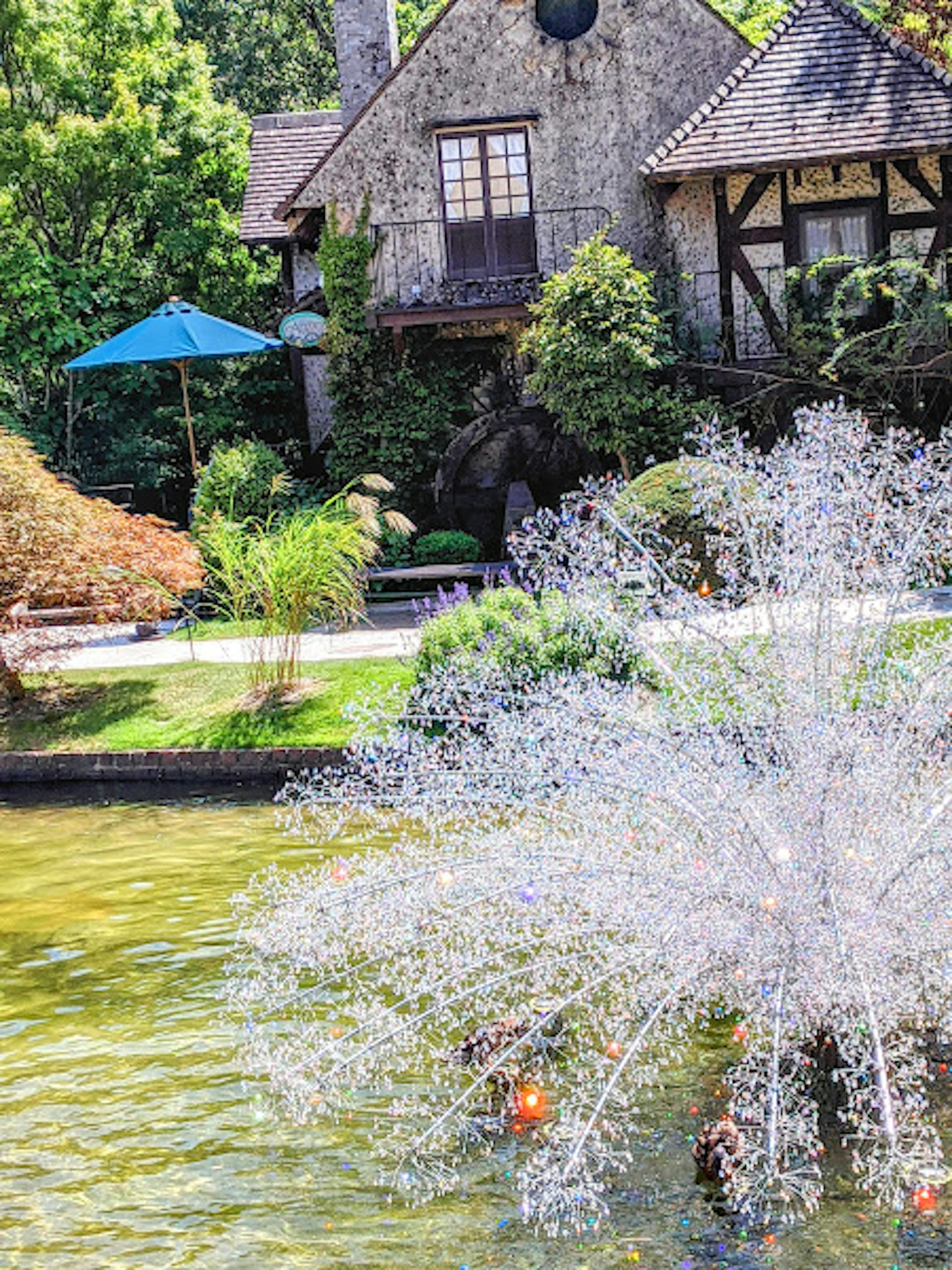 Maison en pierre entourée d'un beau jardin et d'une fontaine