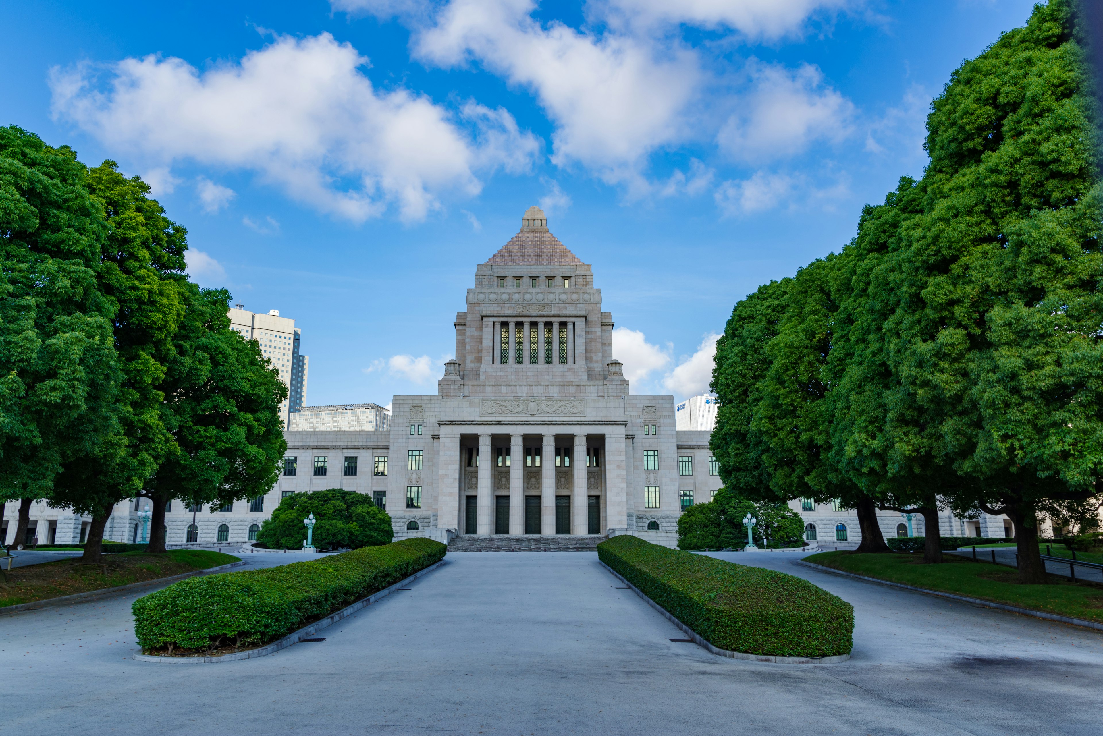 Foreground of the National Diet Building with green trees and blue sky