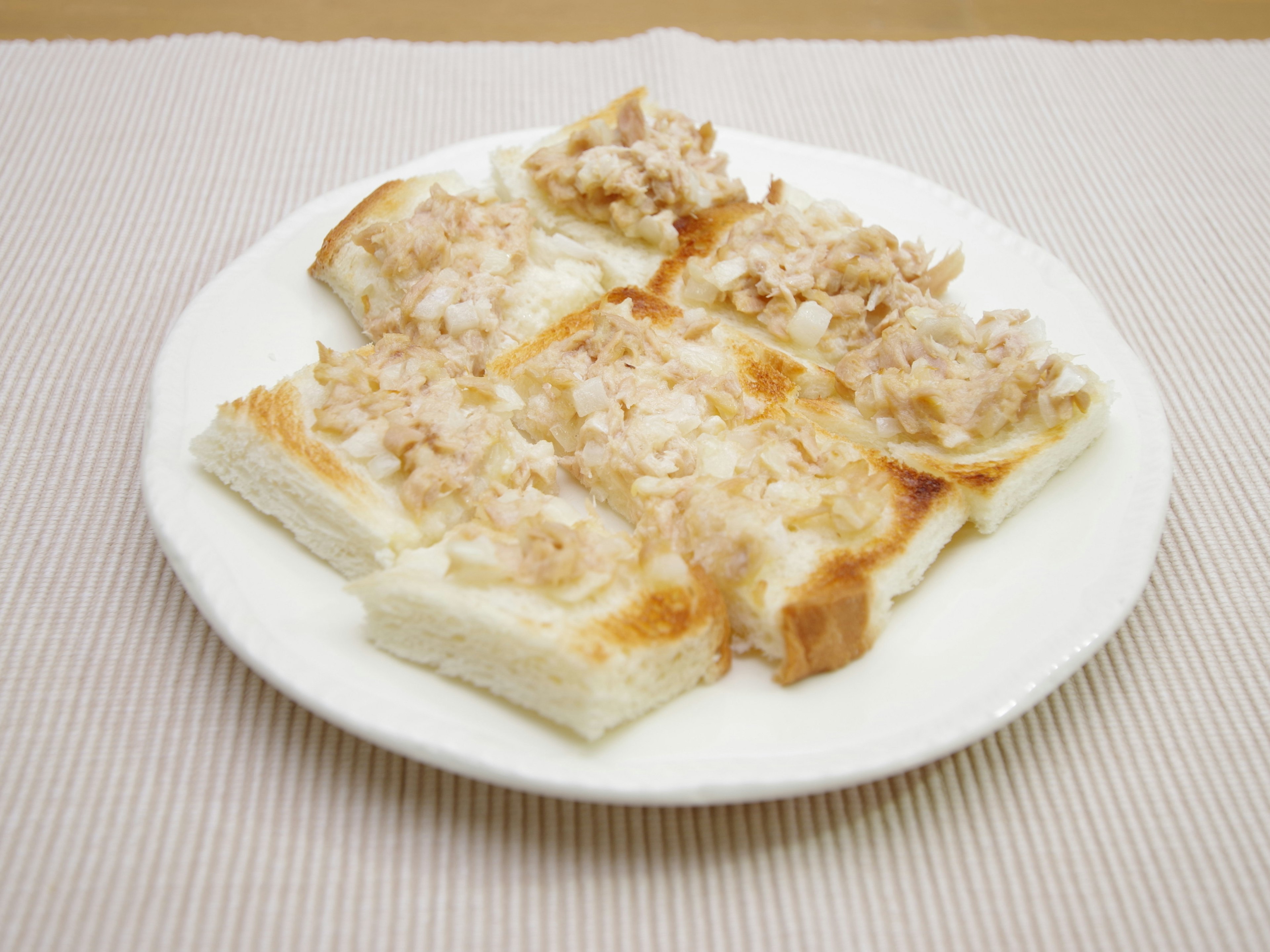 Plato de pan tostado cubierto con ingredientes finamente picados