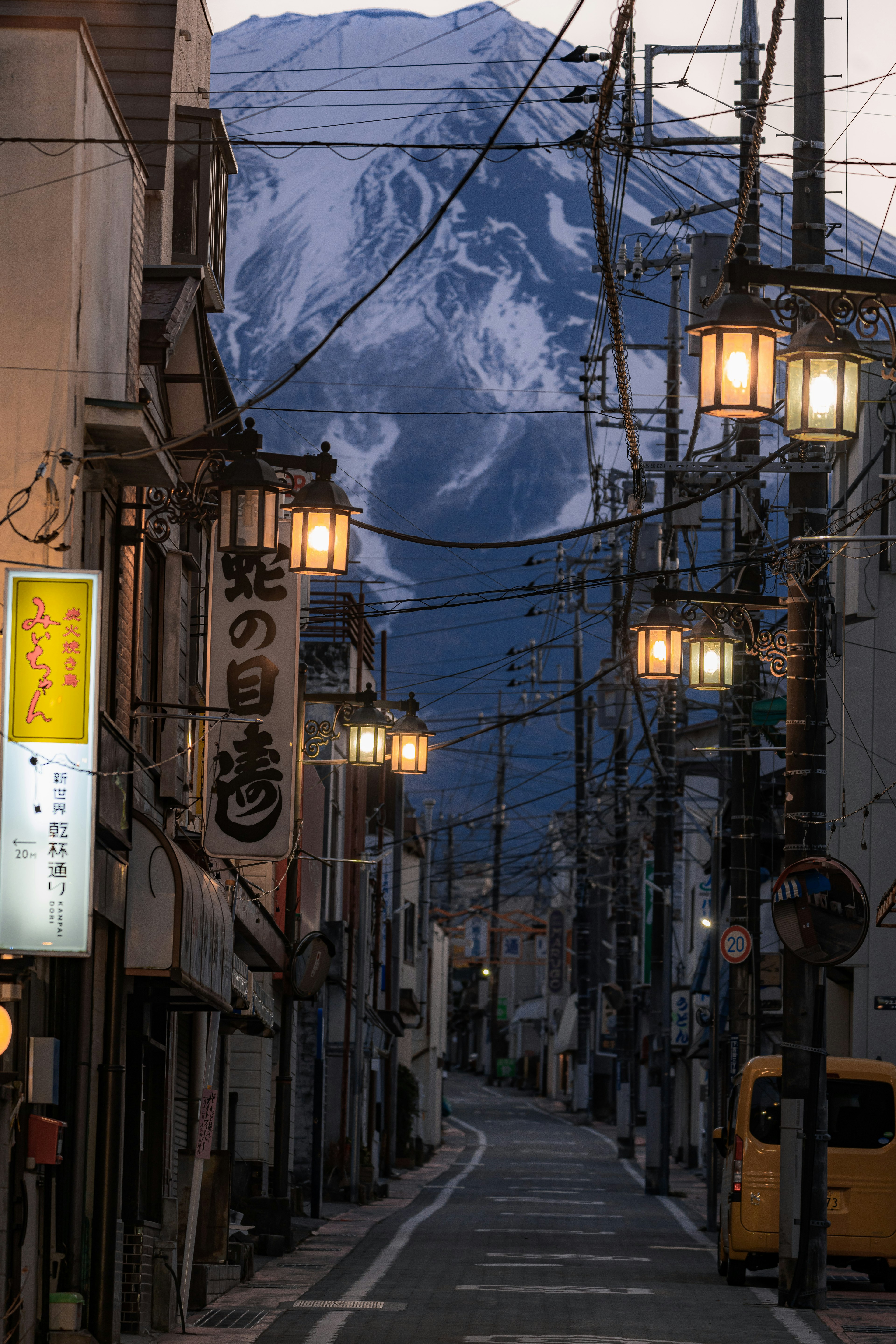 Scène de rue tranquille avec une montagne en arrière-plan et des lampadaires vintage