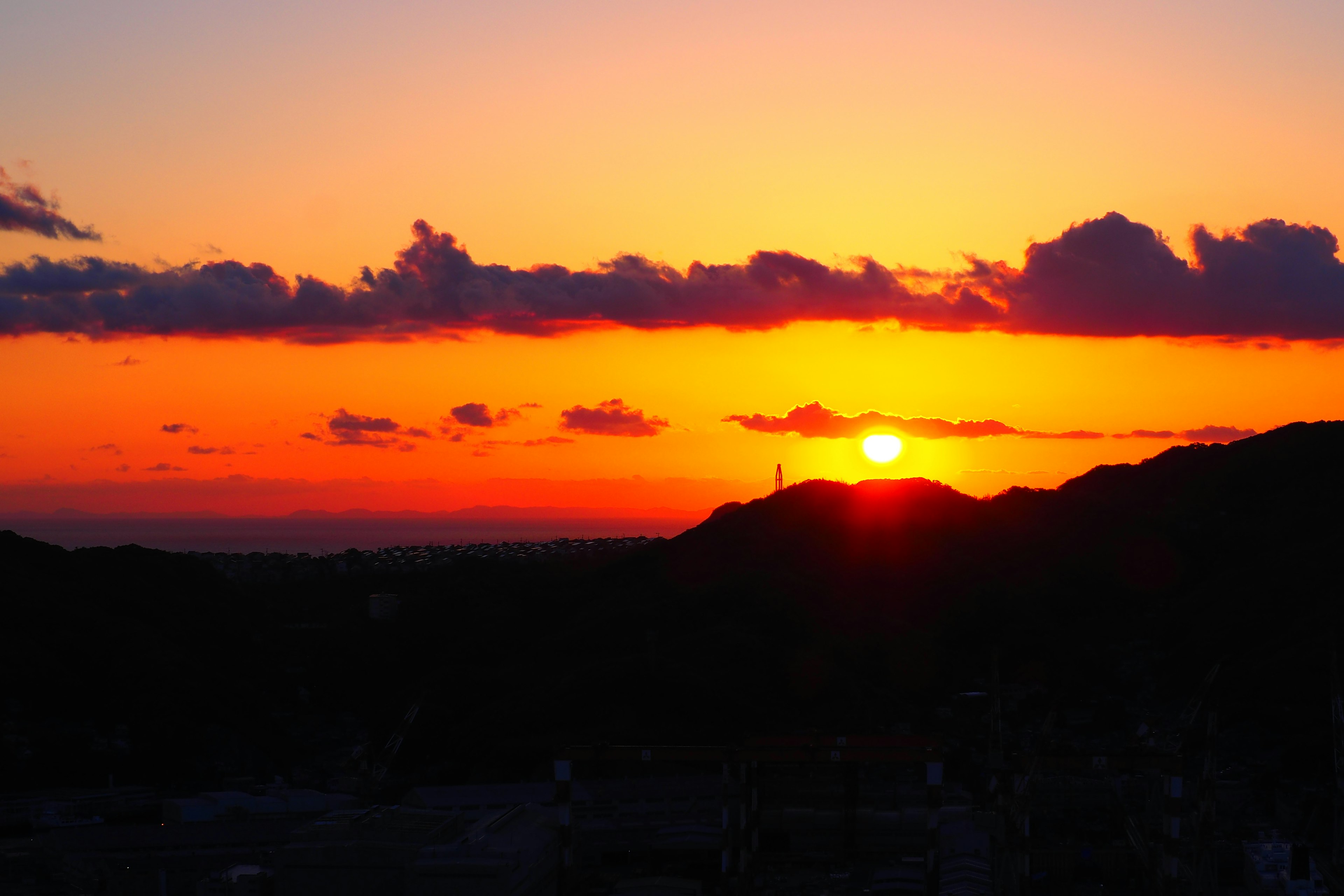 Bellissimo tramonto dietro le montagne con tonalità arancioni e viola