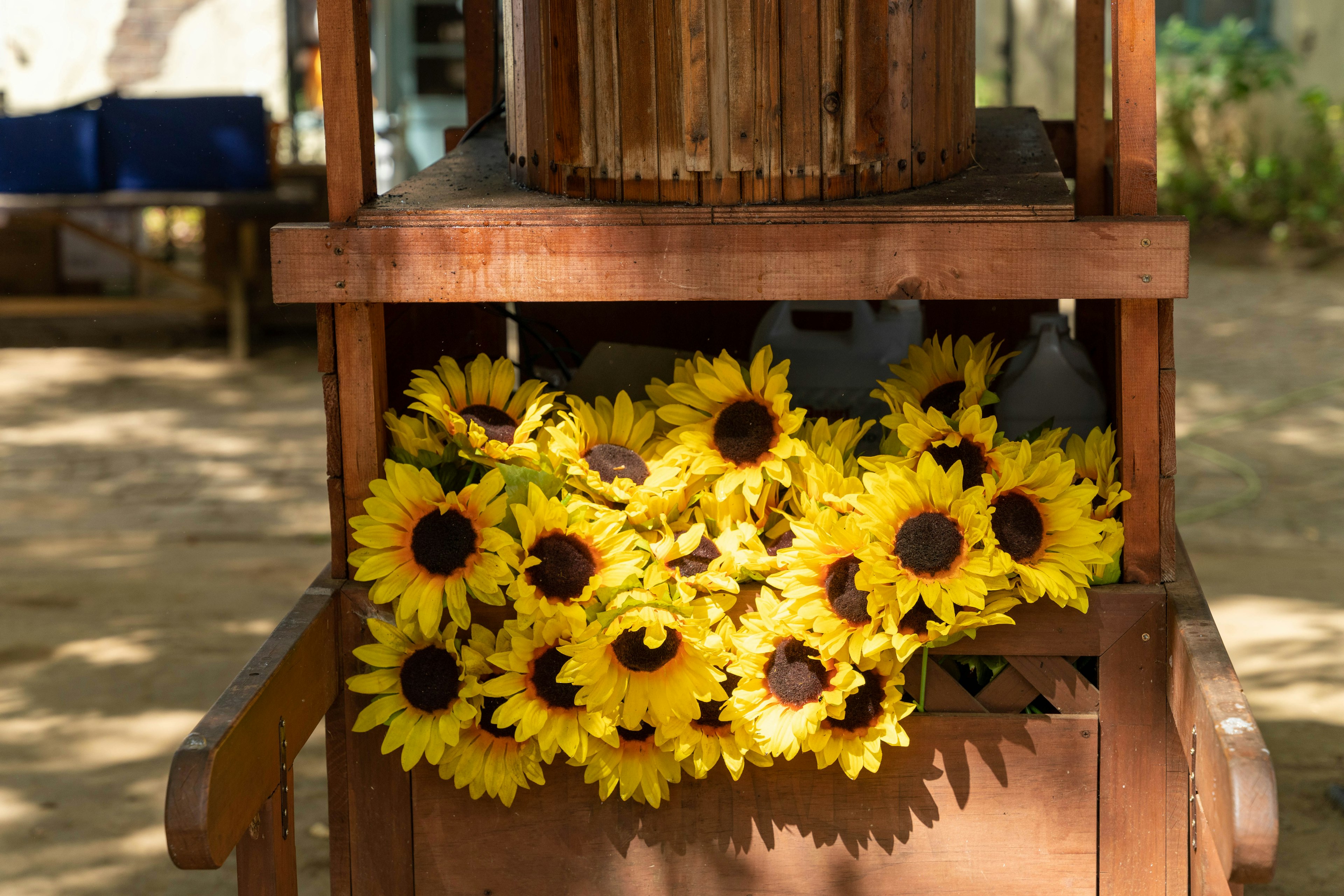 A wooden cart adorned with bright sunflower bouquets