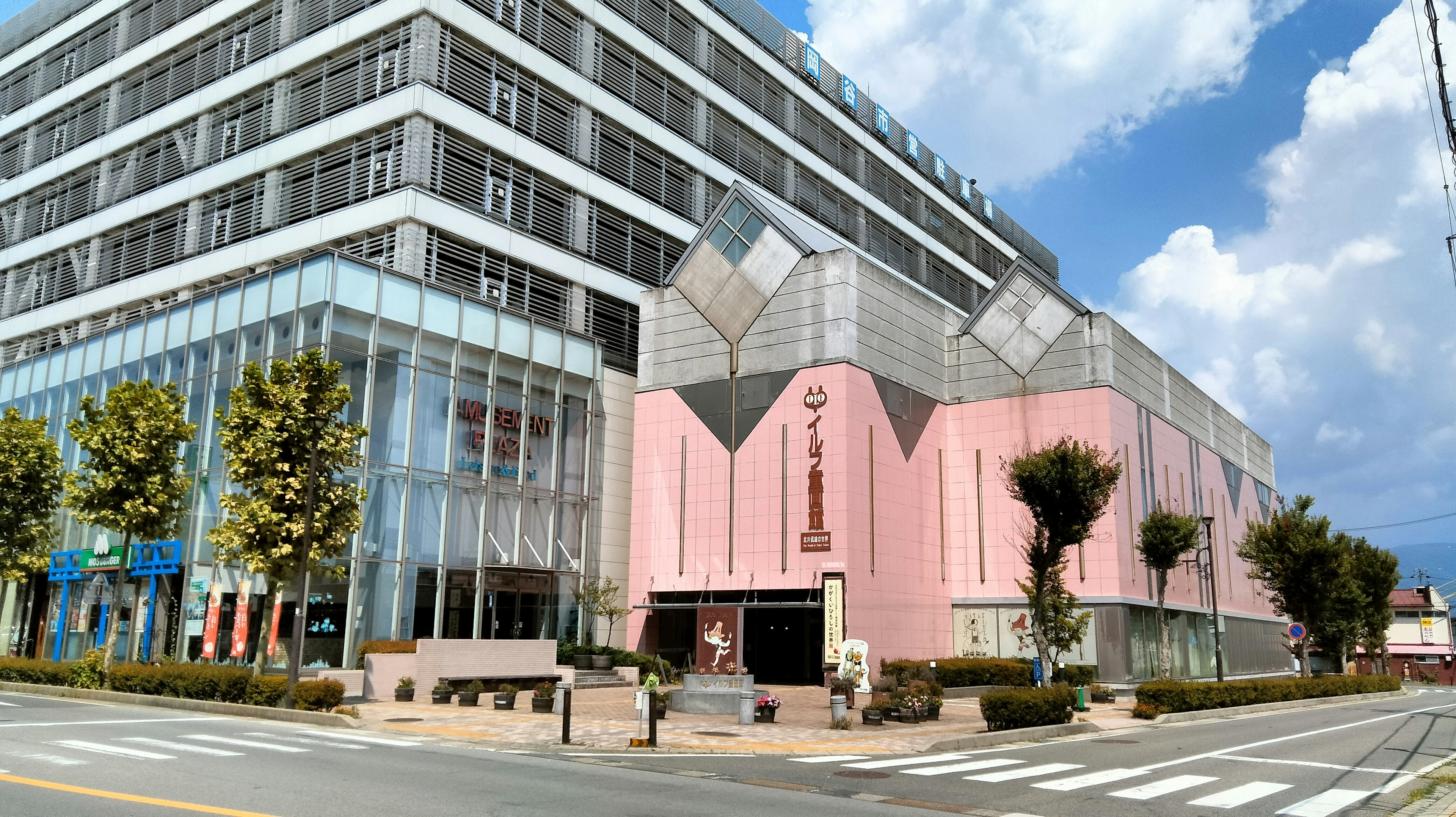 Edificio commerciale con facciata rosa e struttura in vetro moderno