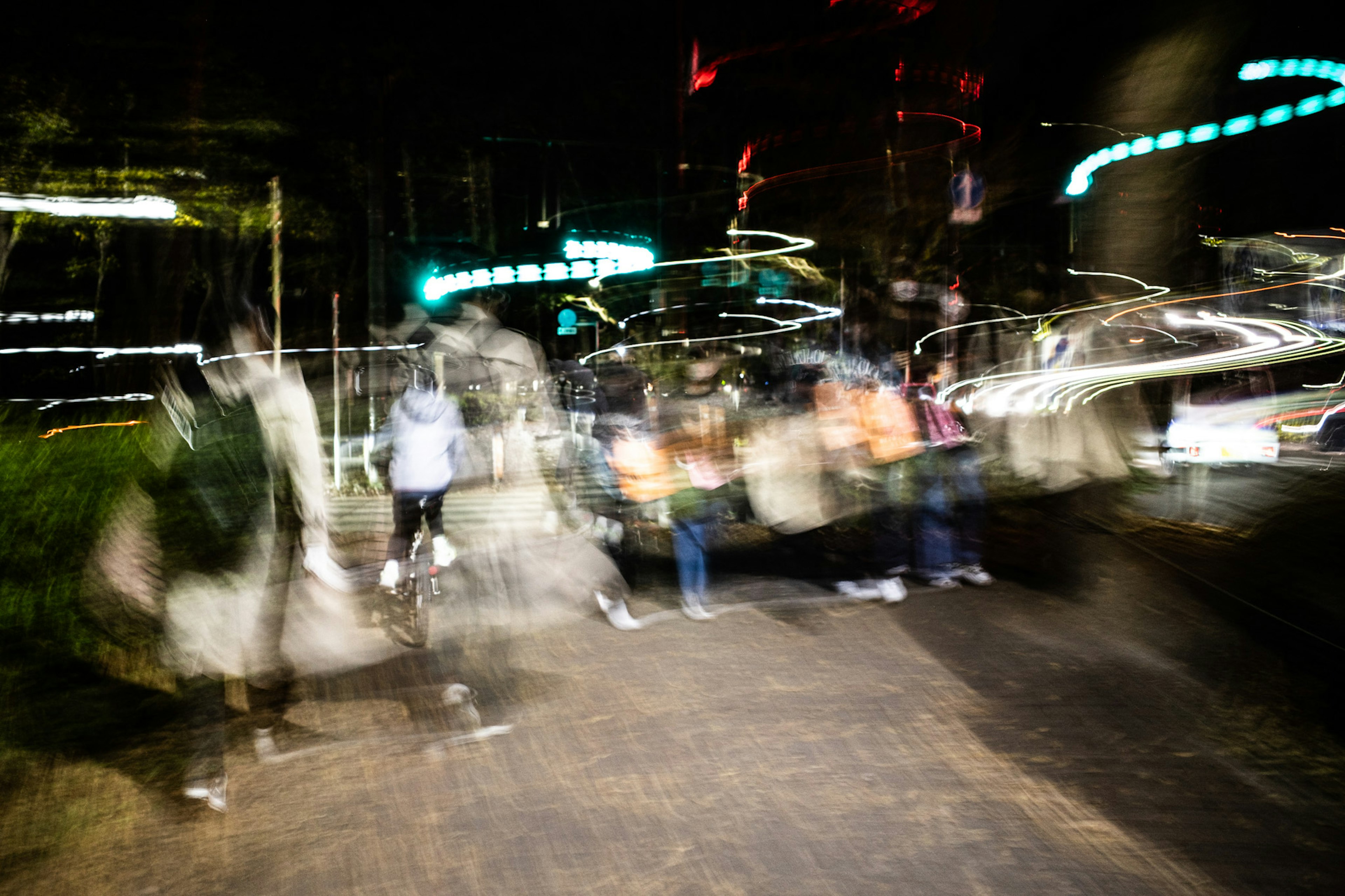 Silhouette sfocate di persone in movimento in una città di notte con scie di luce