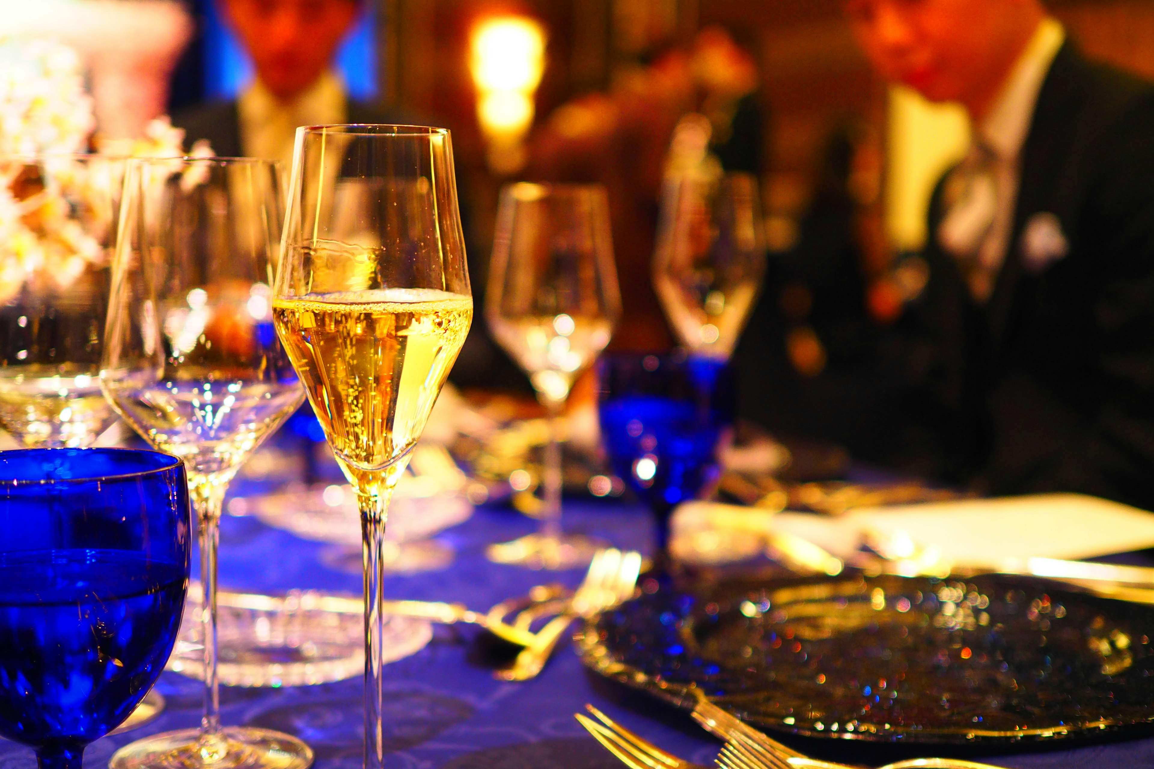 Elegant dinner setting featuring beautiful blue glasses and sparkling champagne