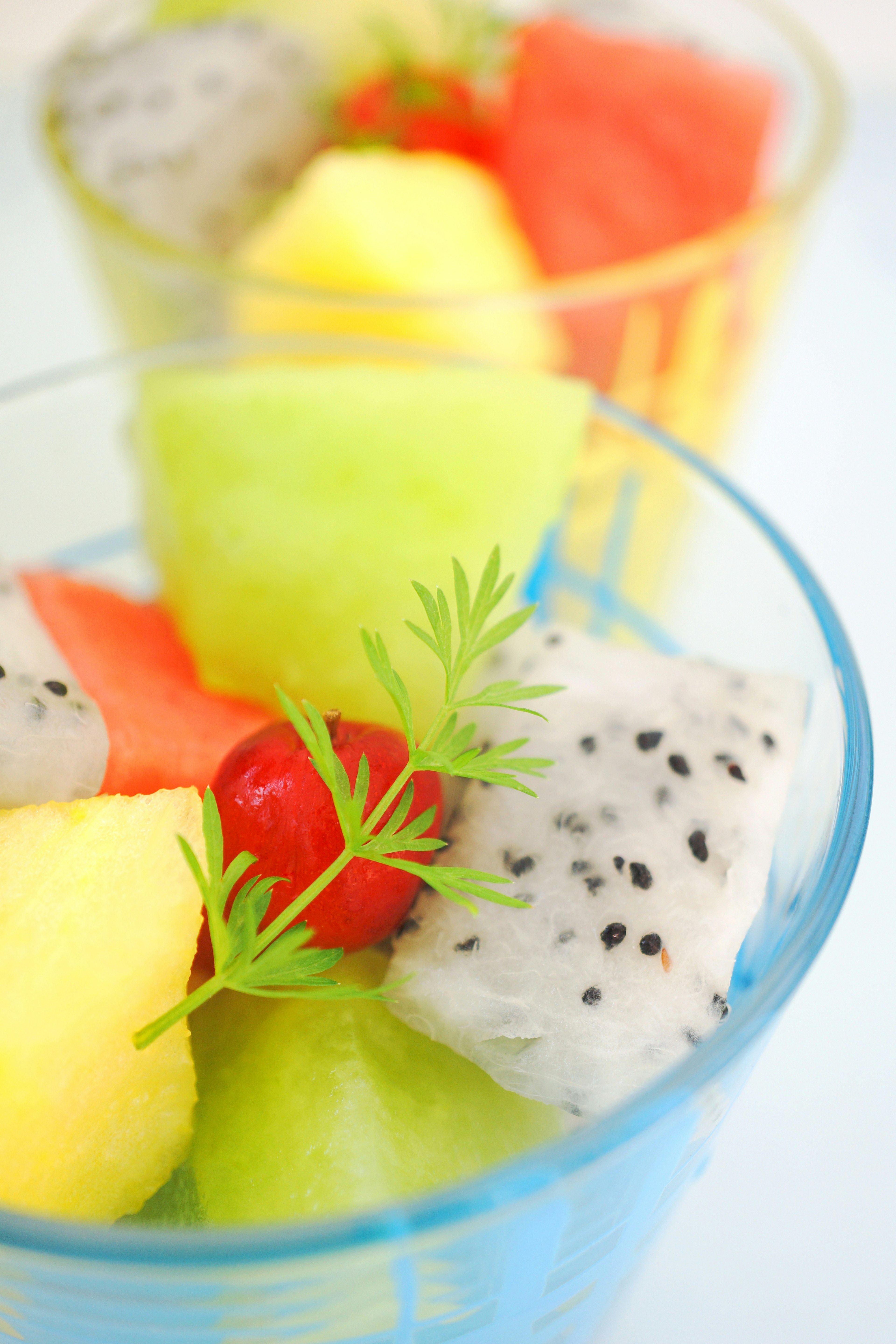 Ensalada de frutas colorida en copas transparentes con melón sandía piña y fruta del dragón