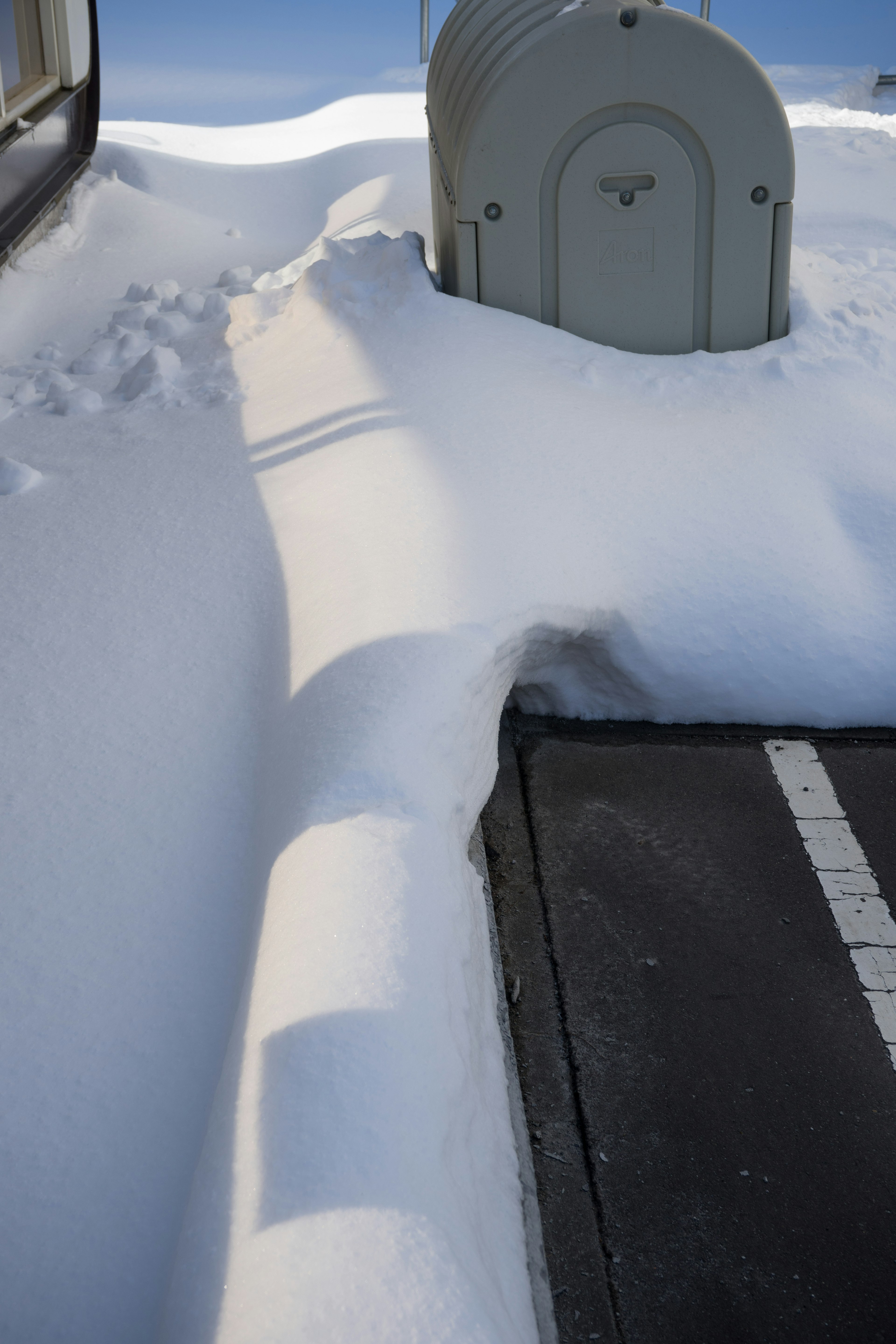 Schneebedeckter Gehweg mit einem Briefkasten