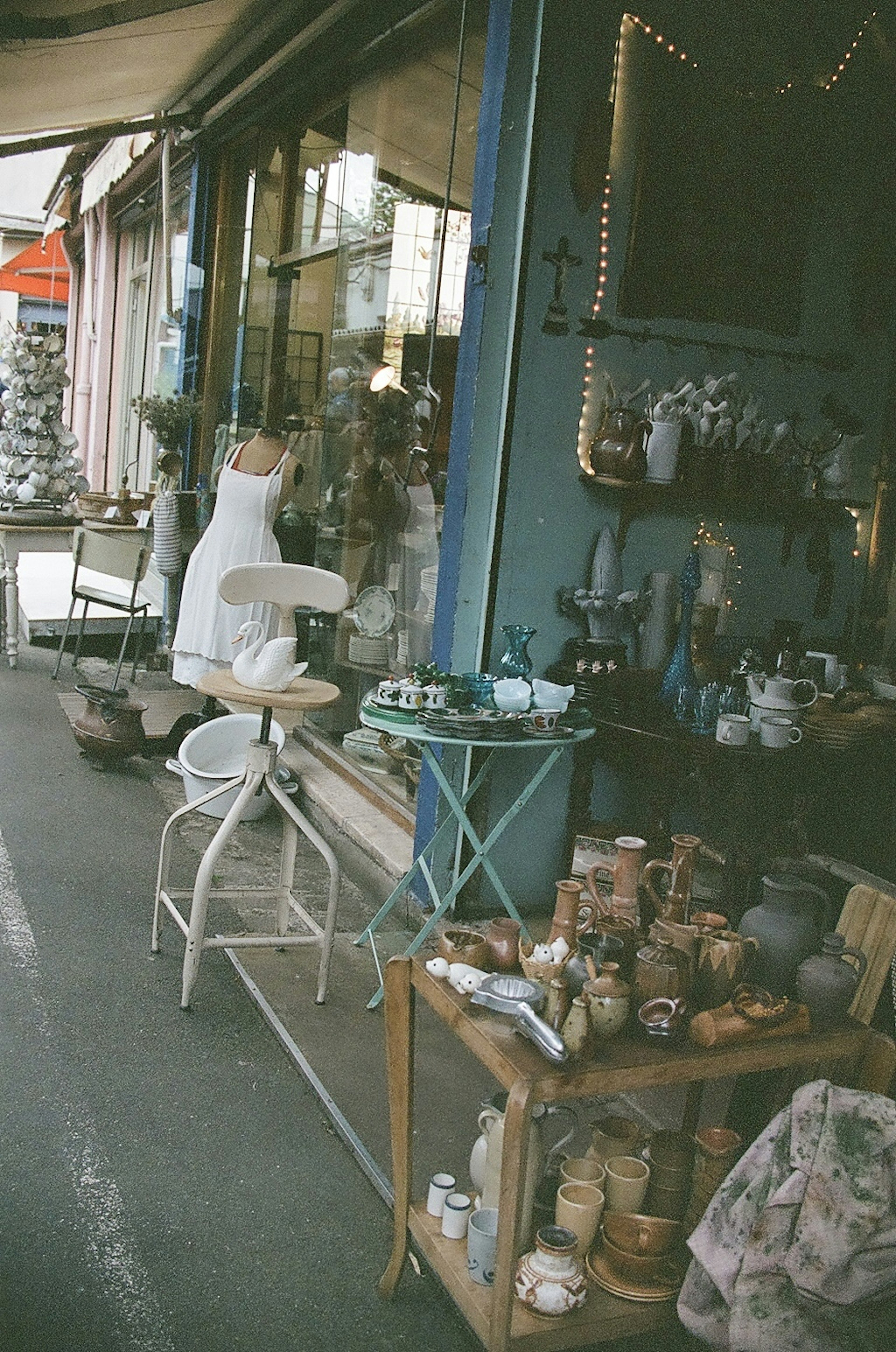 Exterior of an antique shop featuring a blue wall and various objects displayed