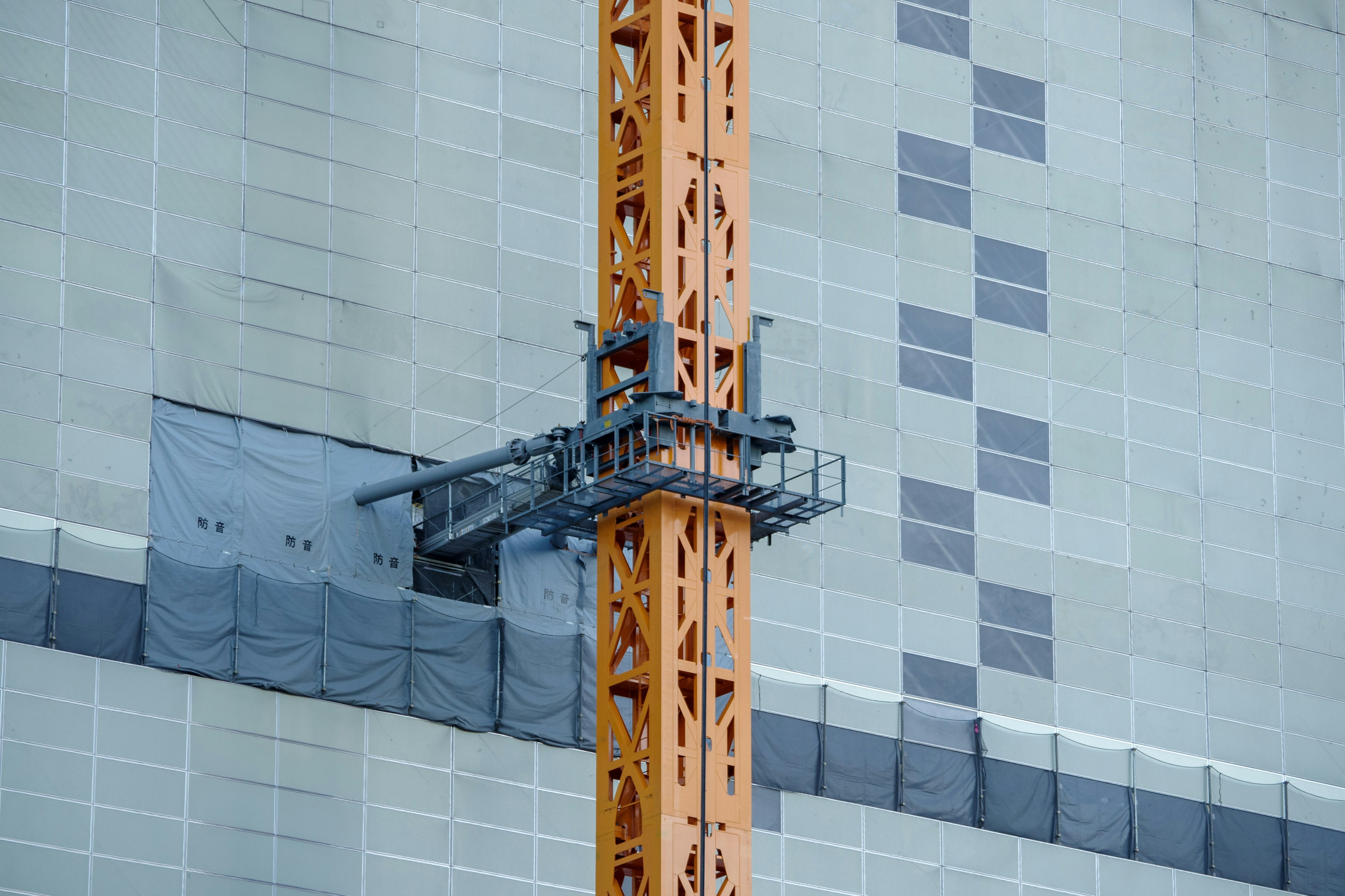 Grue de construction et plateforme de travail sur un immeuble de grande hauteur