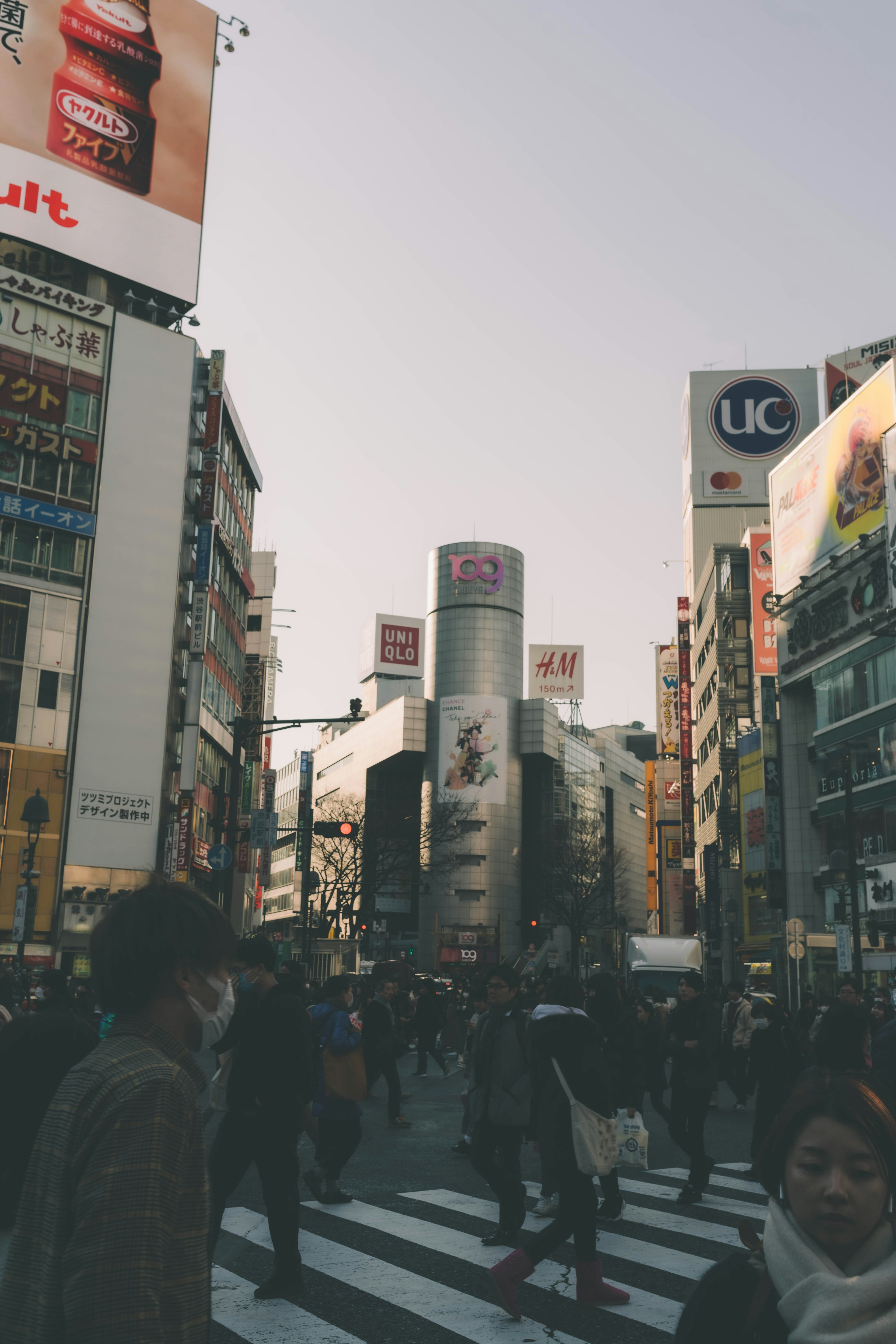 渋谷の繁華街で人々が交差点を渡る様子 近くには高層ビルと広告が見える