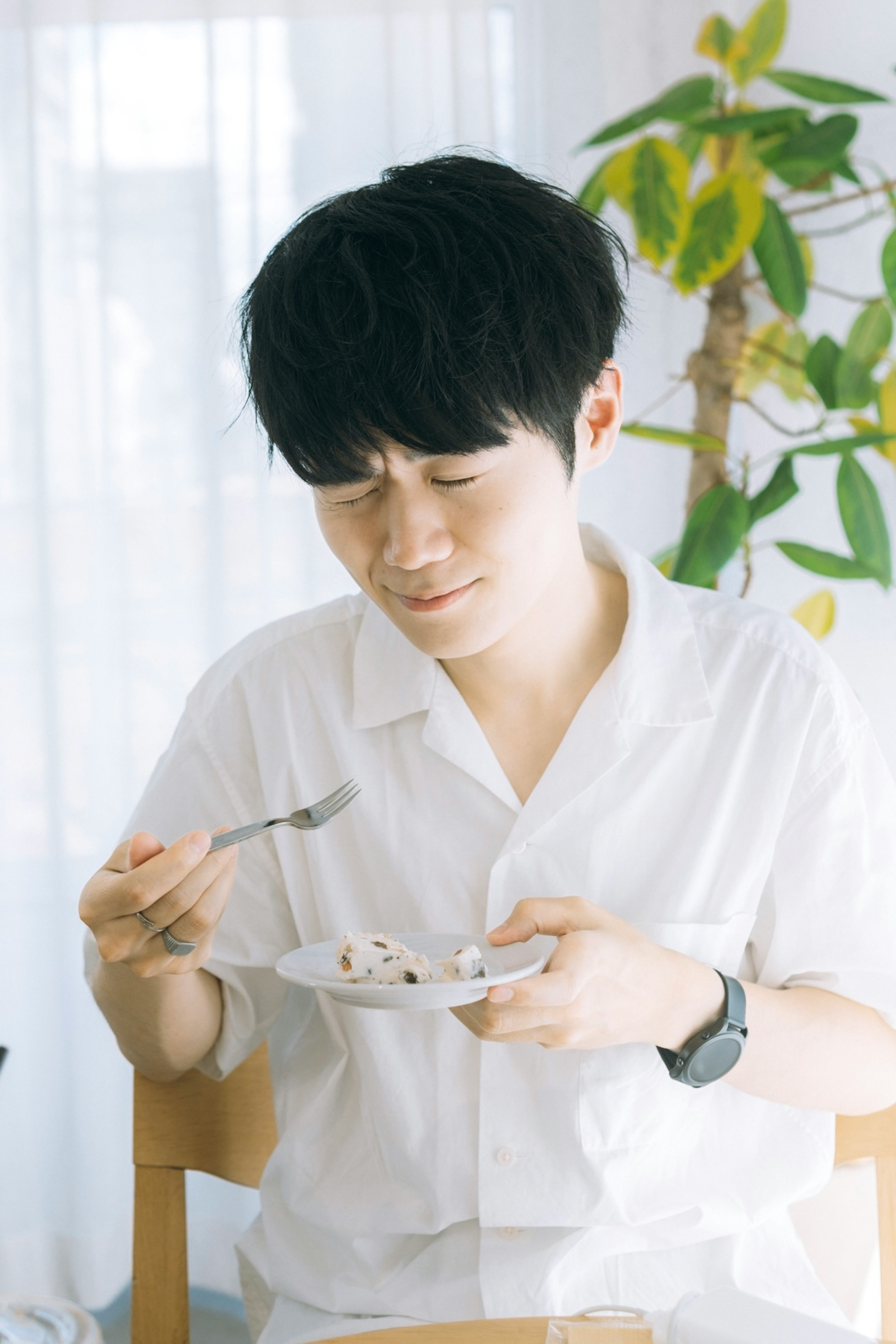 Joven en camisa blanca disfrutando de una comida en un plato