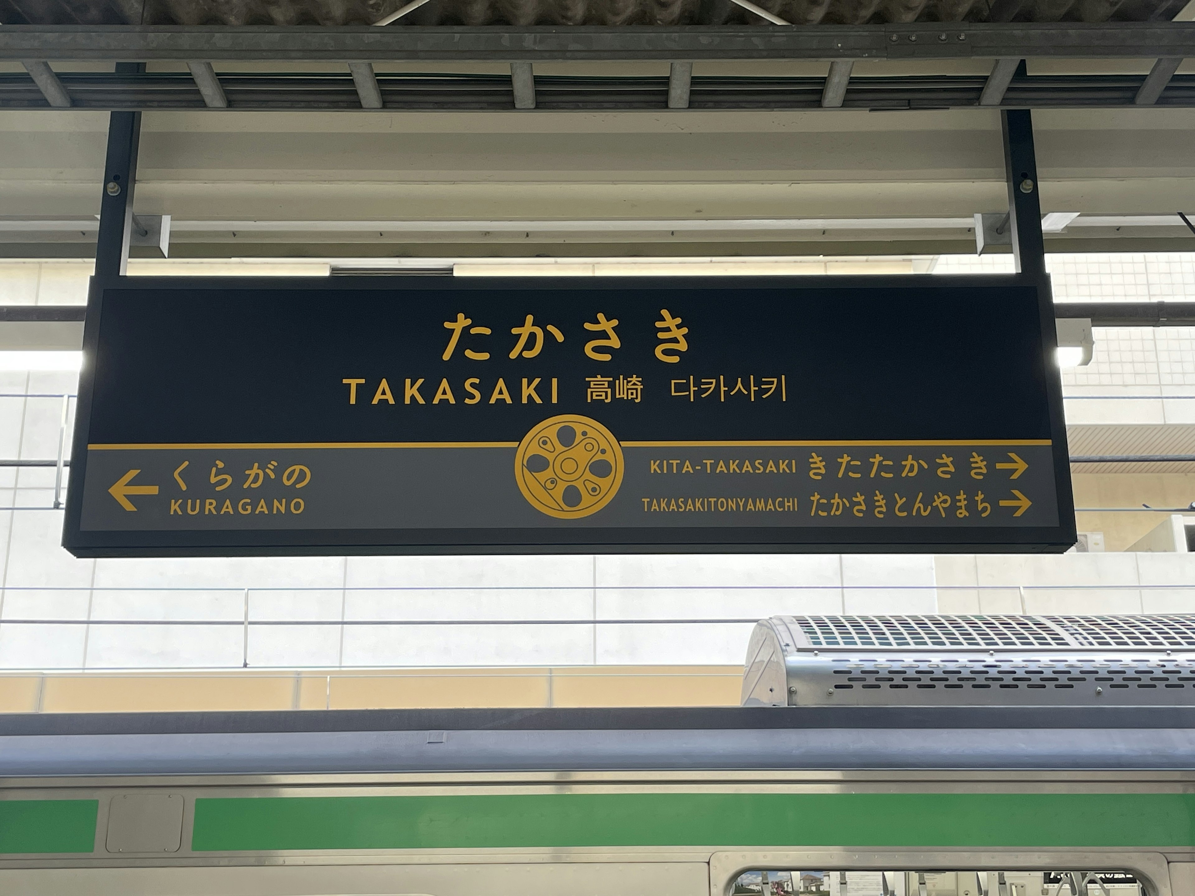 Papan nama Stasiun Takasaki menampilkan nama dalam bahasa Jepang dan Inggris