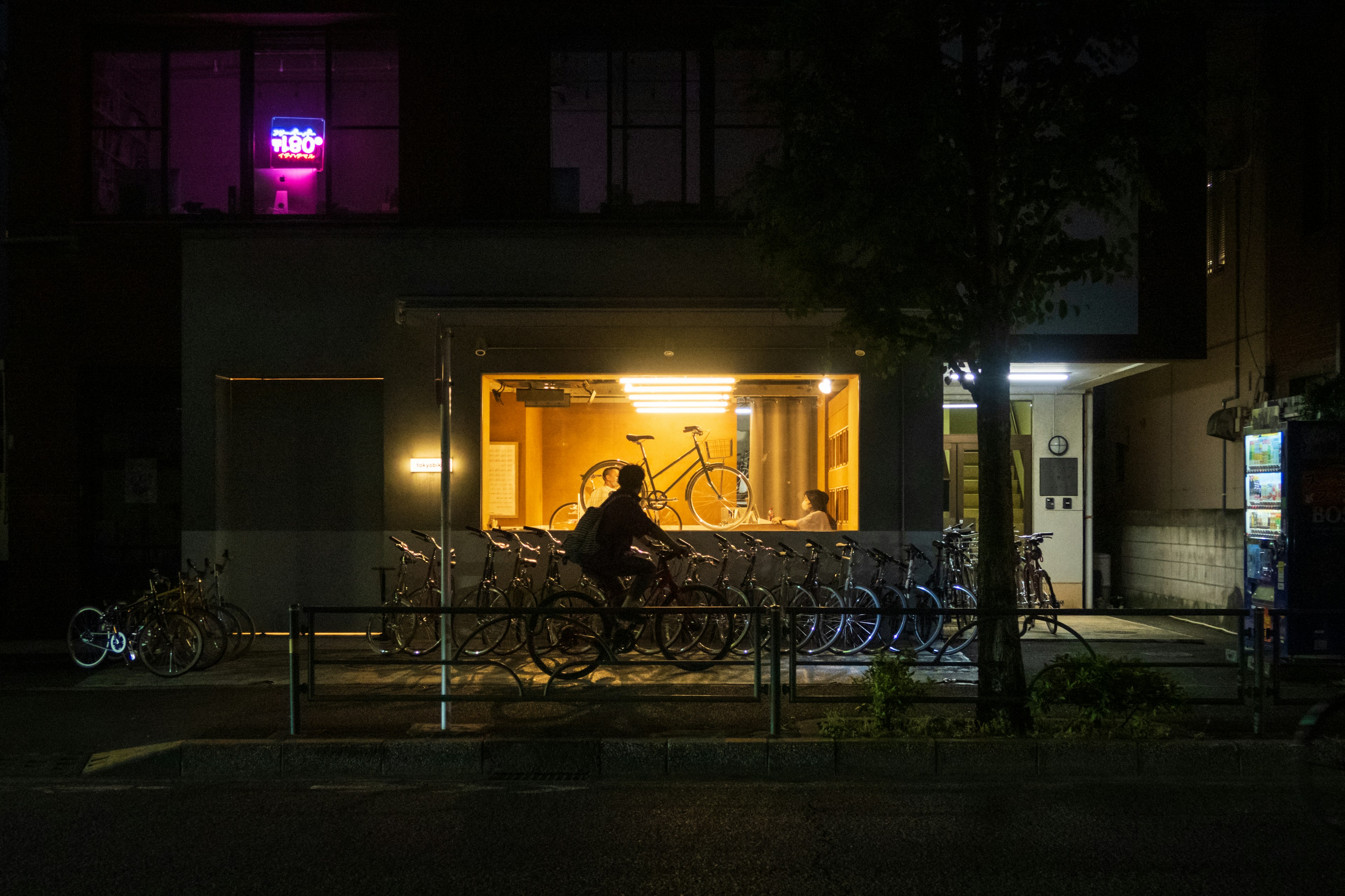 夜の街の自転車と明るい窓のある建物