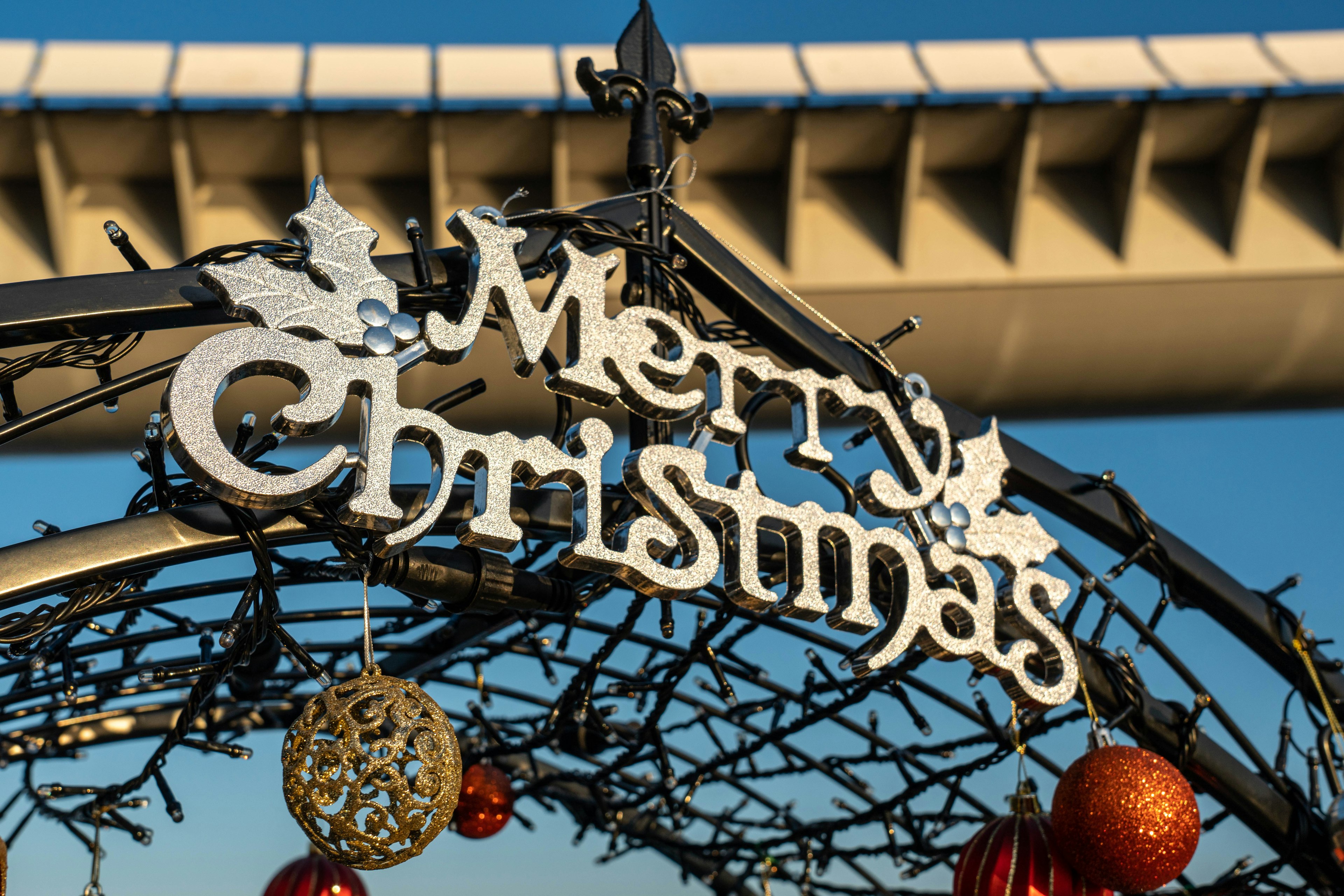 A decorative arch with the words Merry Christmas adorned with ornaments and festive elements