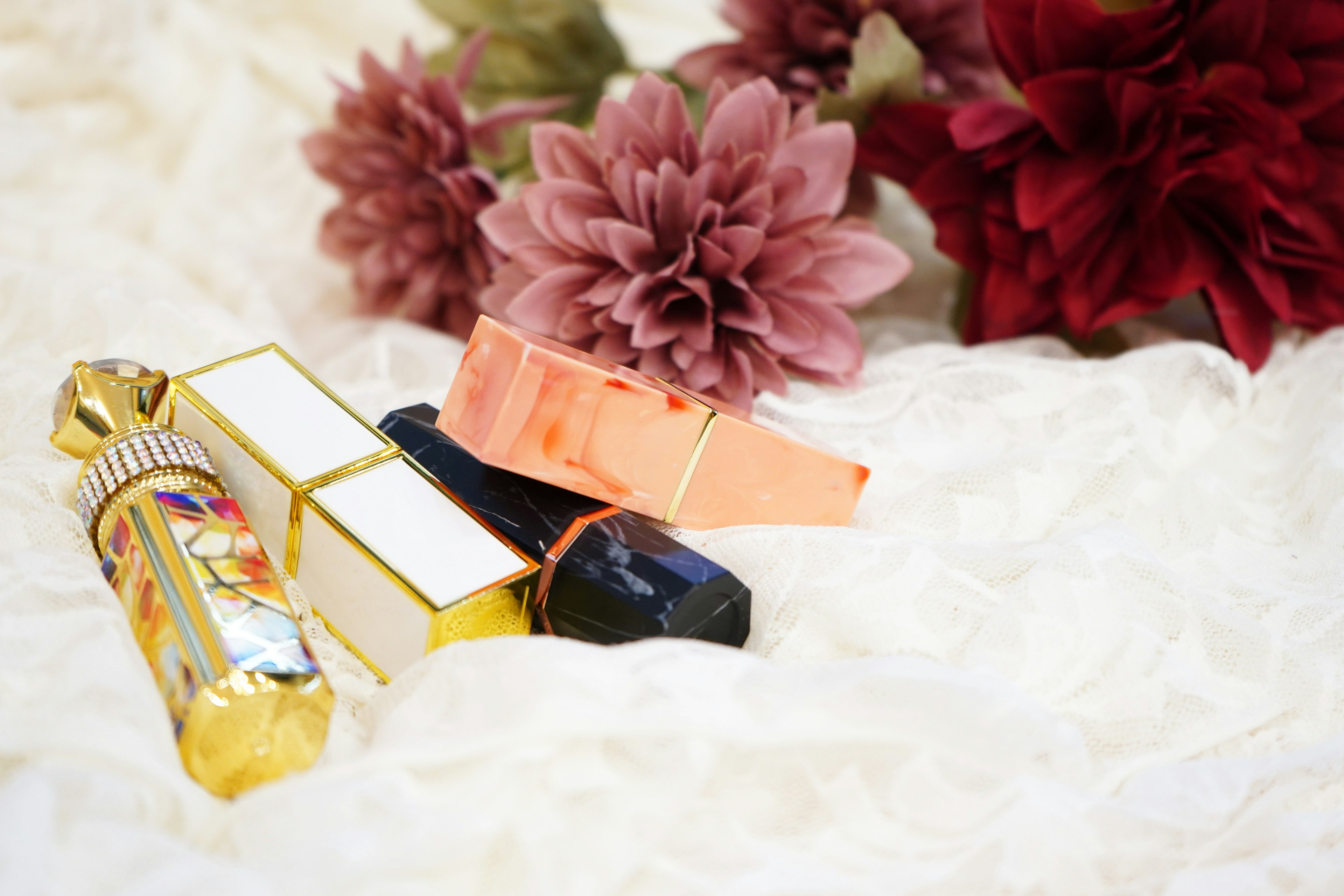 Colorful lipsticks arranged with large flowers in the background