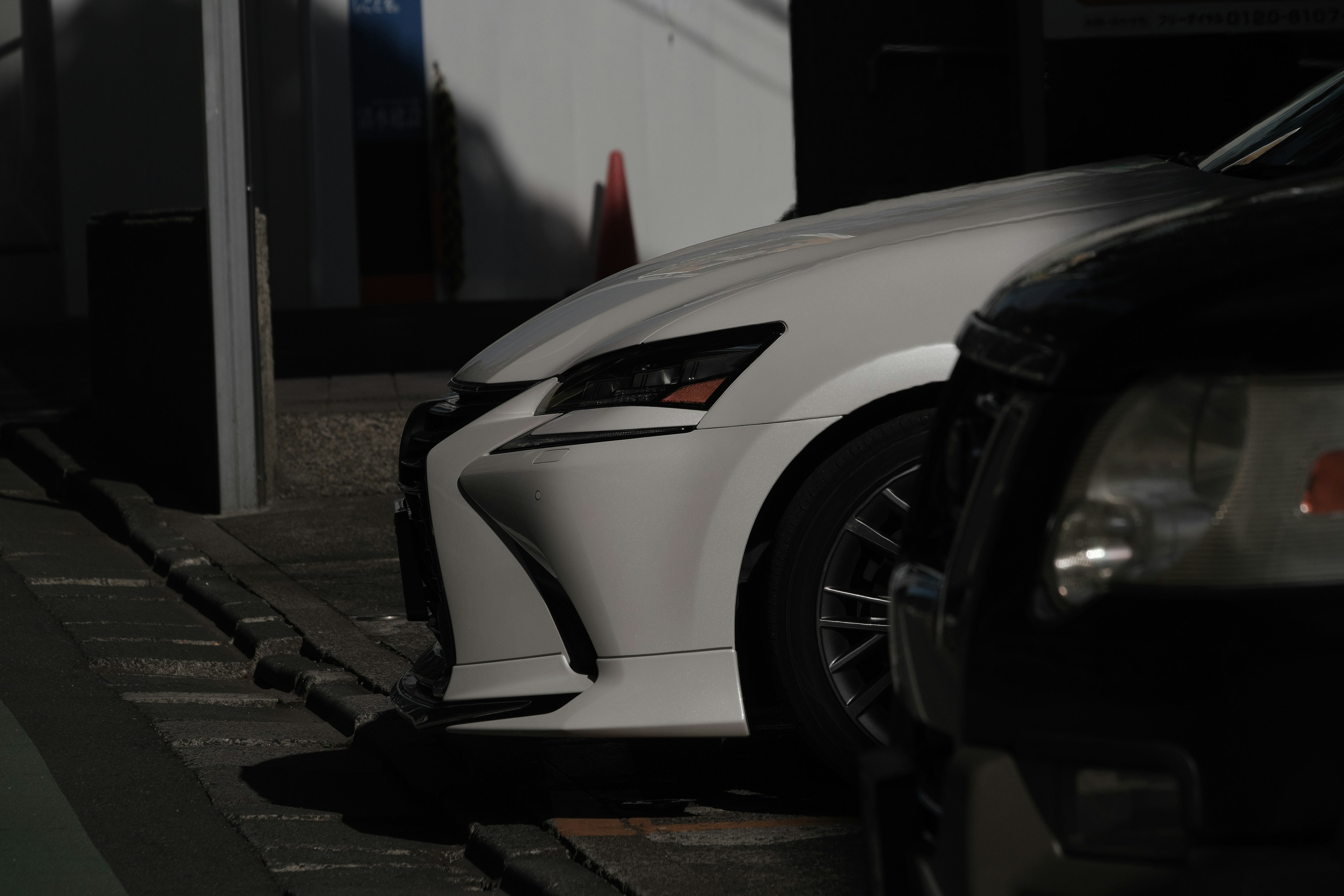 Vista frontale di una Lexus bianca parcheggiata in un'area poco illuminata