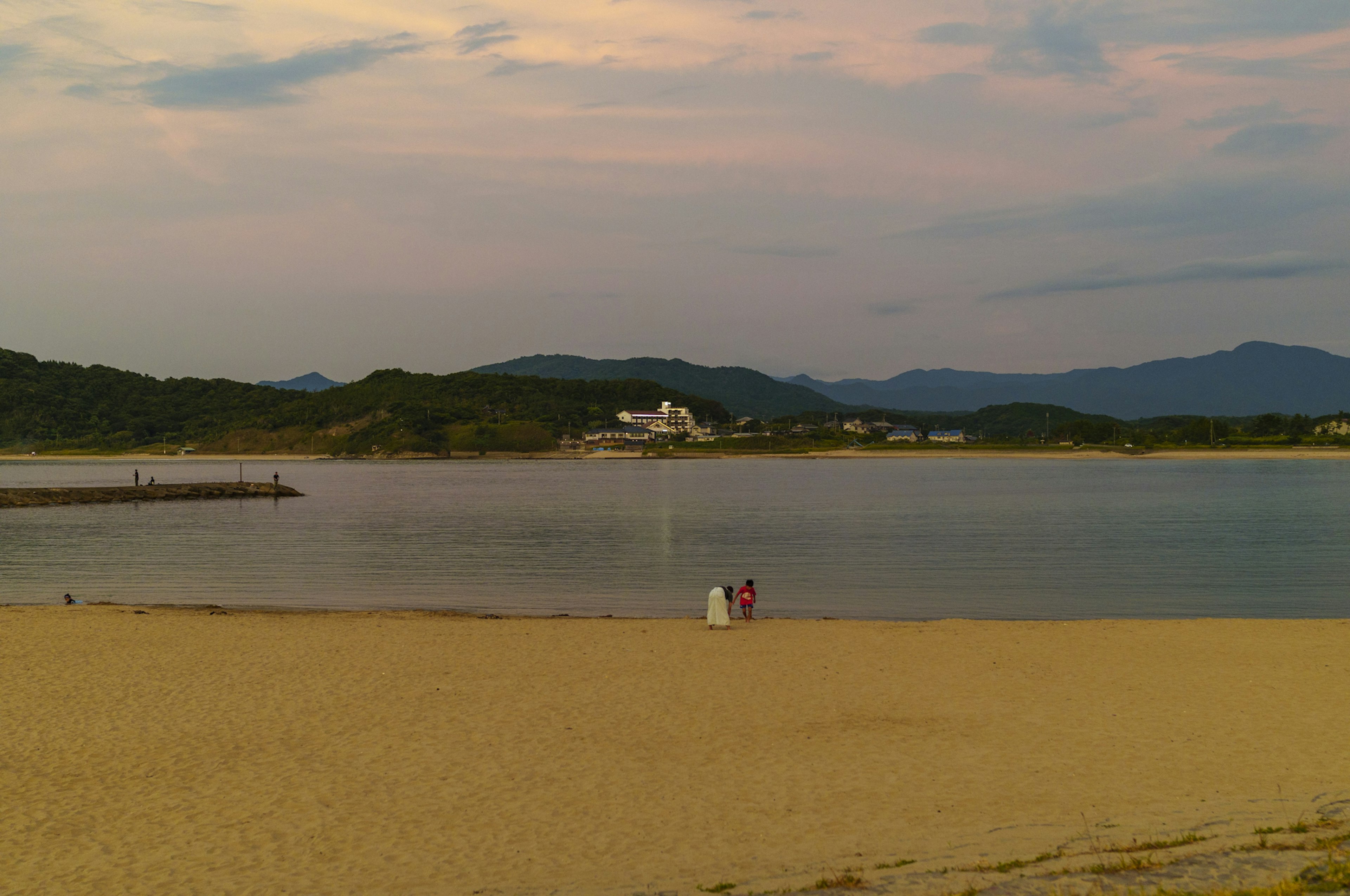 Scena di spiaggia serena con acque calme e montagne in lontananza