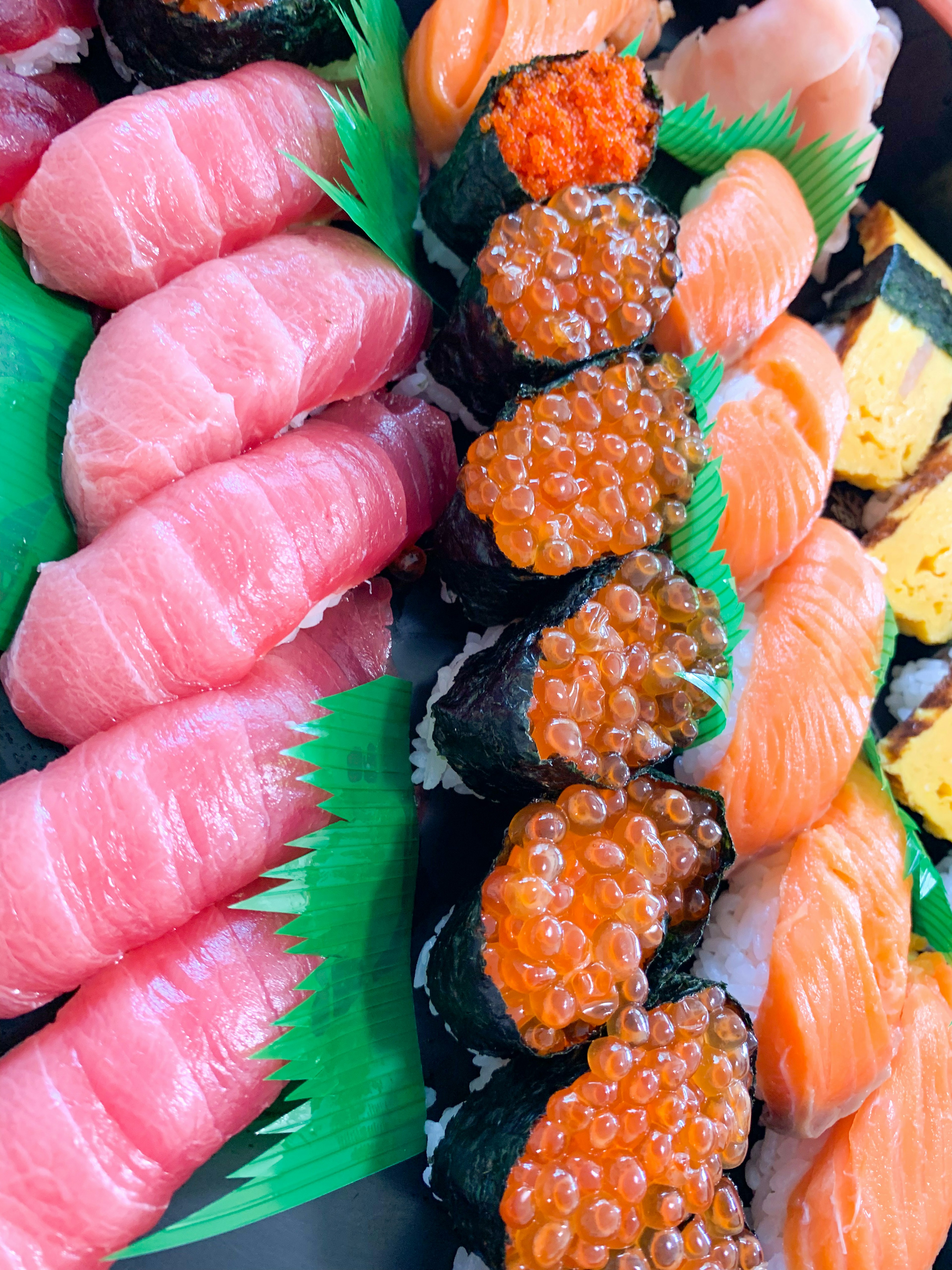 Một bộ sưu tập sushi đầy màu sắc với nhiều loại khác nhau bao gồm cá ngừ, cá hồi và trứng cá