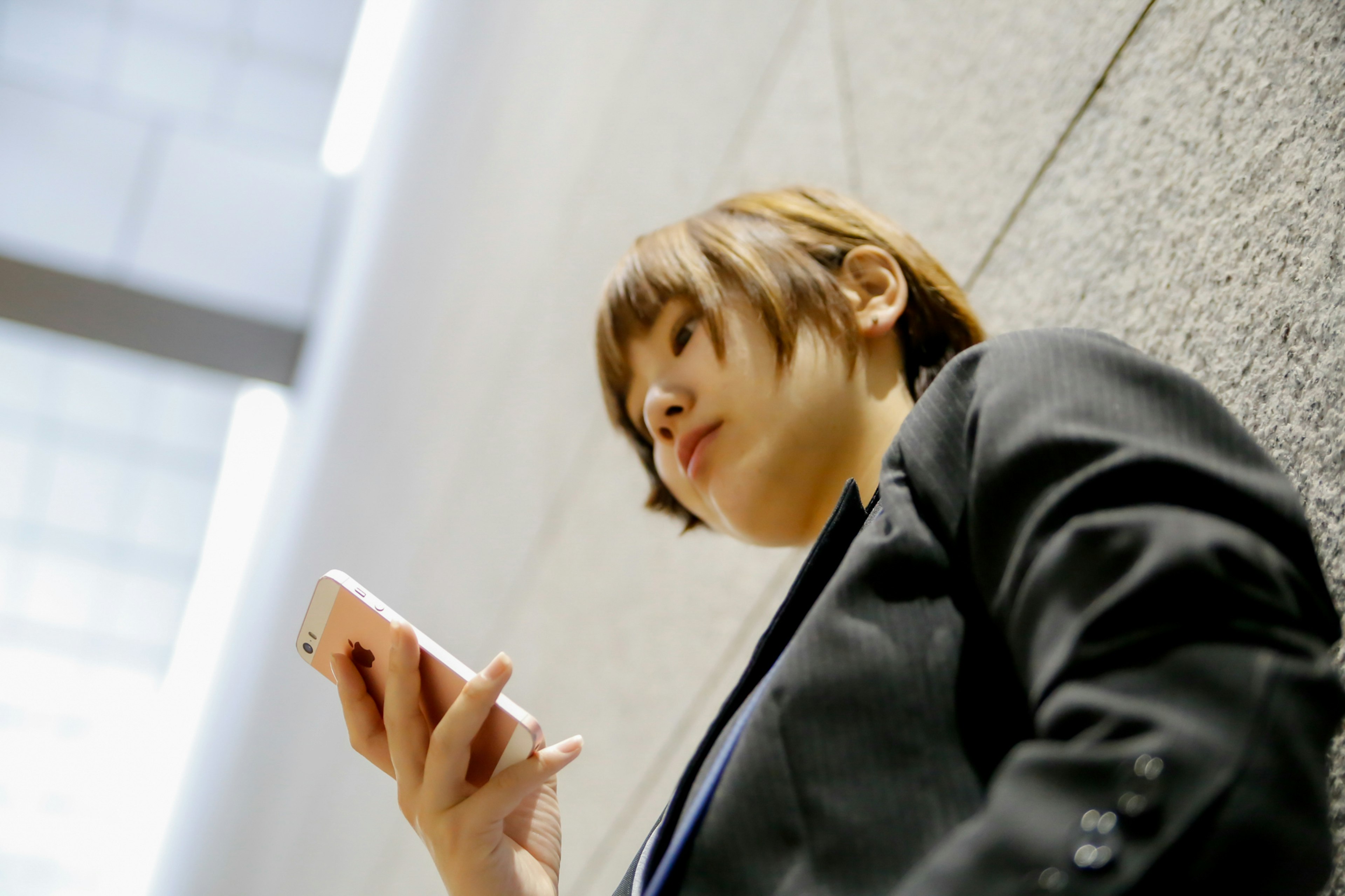 Young woman in a business suit holding a smartphone