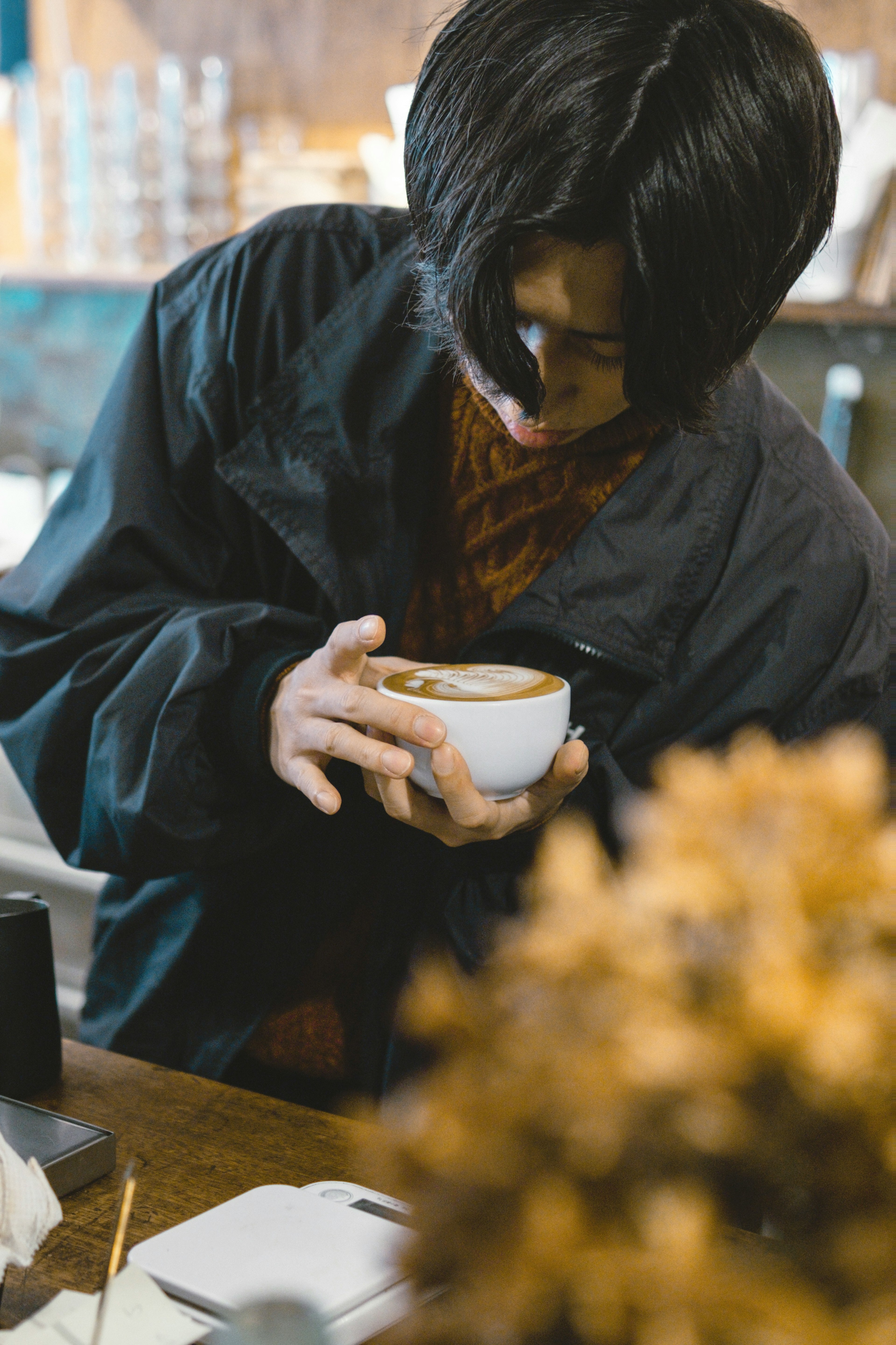 年輕男性在咖啡館中拿著咖啡杯