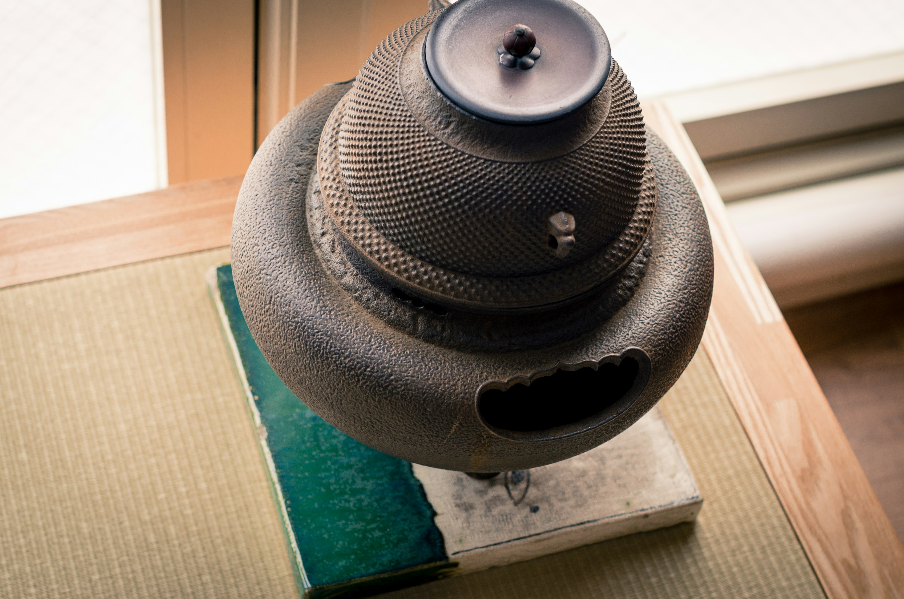 A traditional Japanese iron teapot placed on a tatami mat