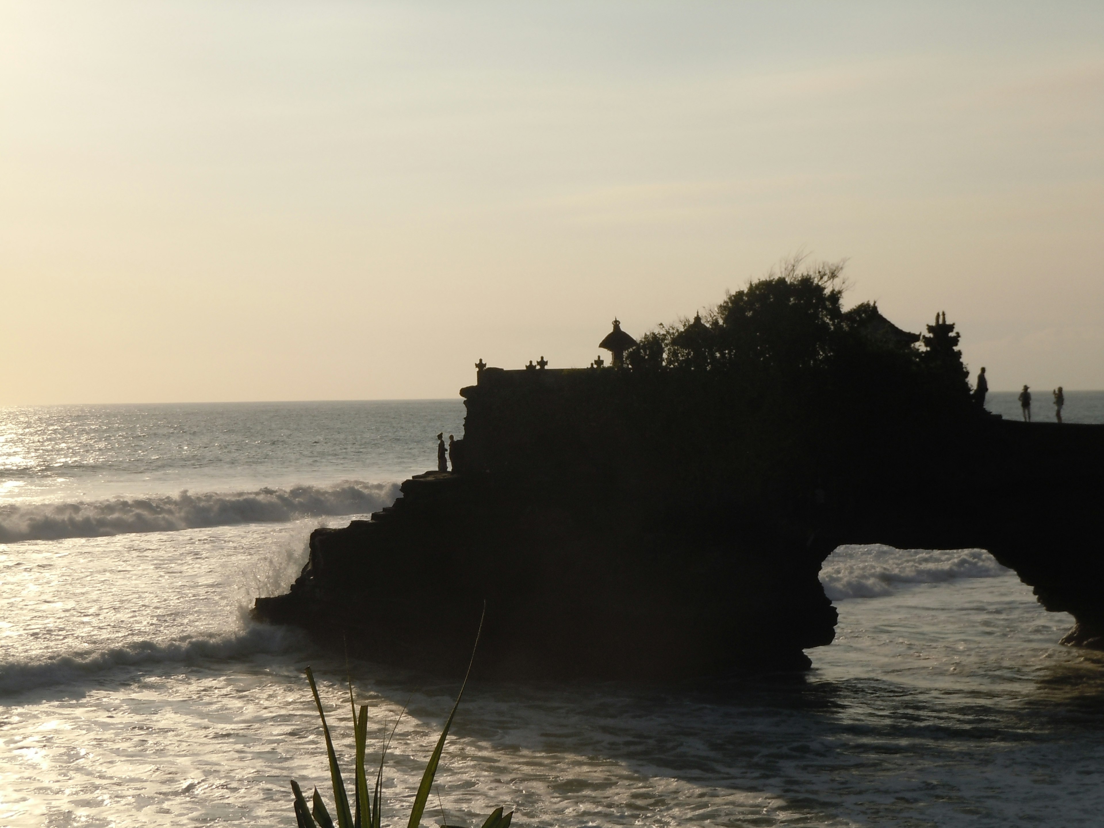 Silhouette d'un temple sur la côte avec un coucher de soleil en arrière-plan