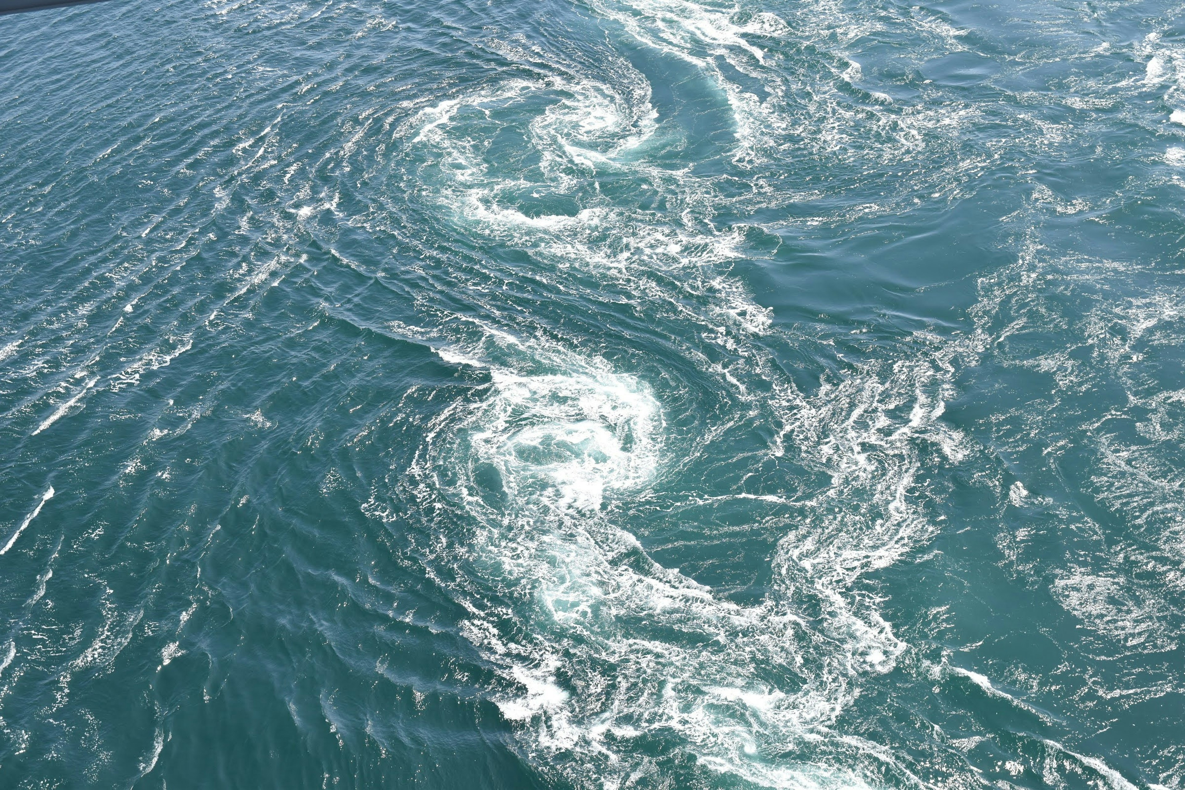 Swirling waves and foam patterns on the water surface