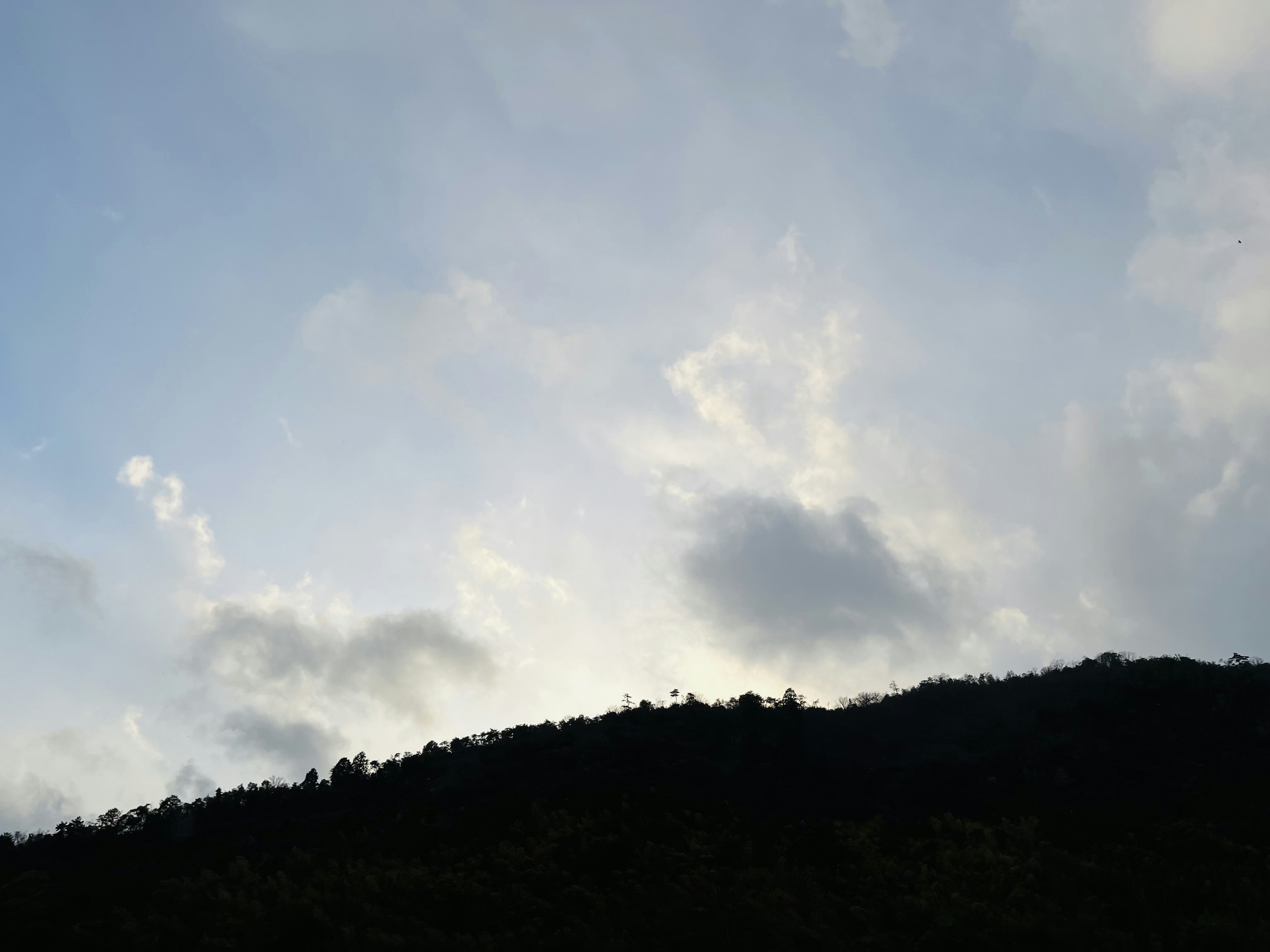 山のシルエットと青空の雲