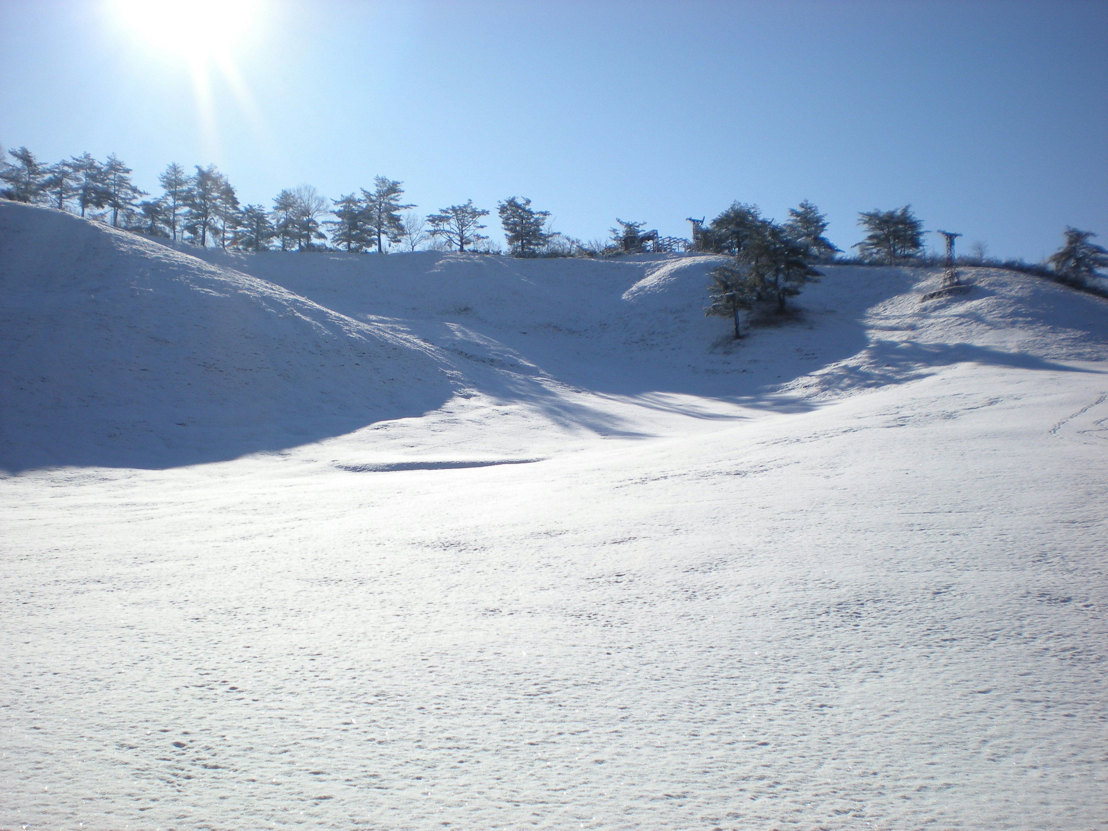 Snow-covered hills under a clear blue sky