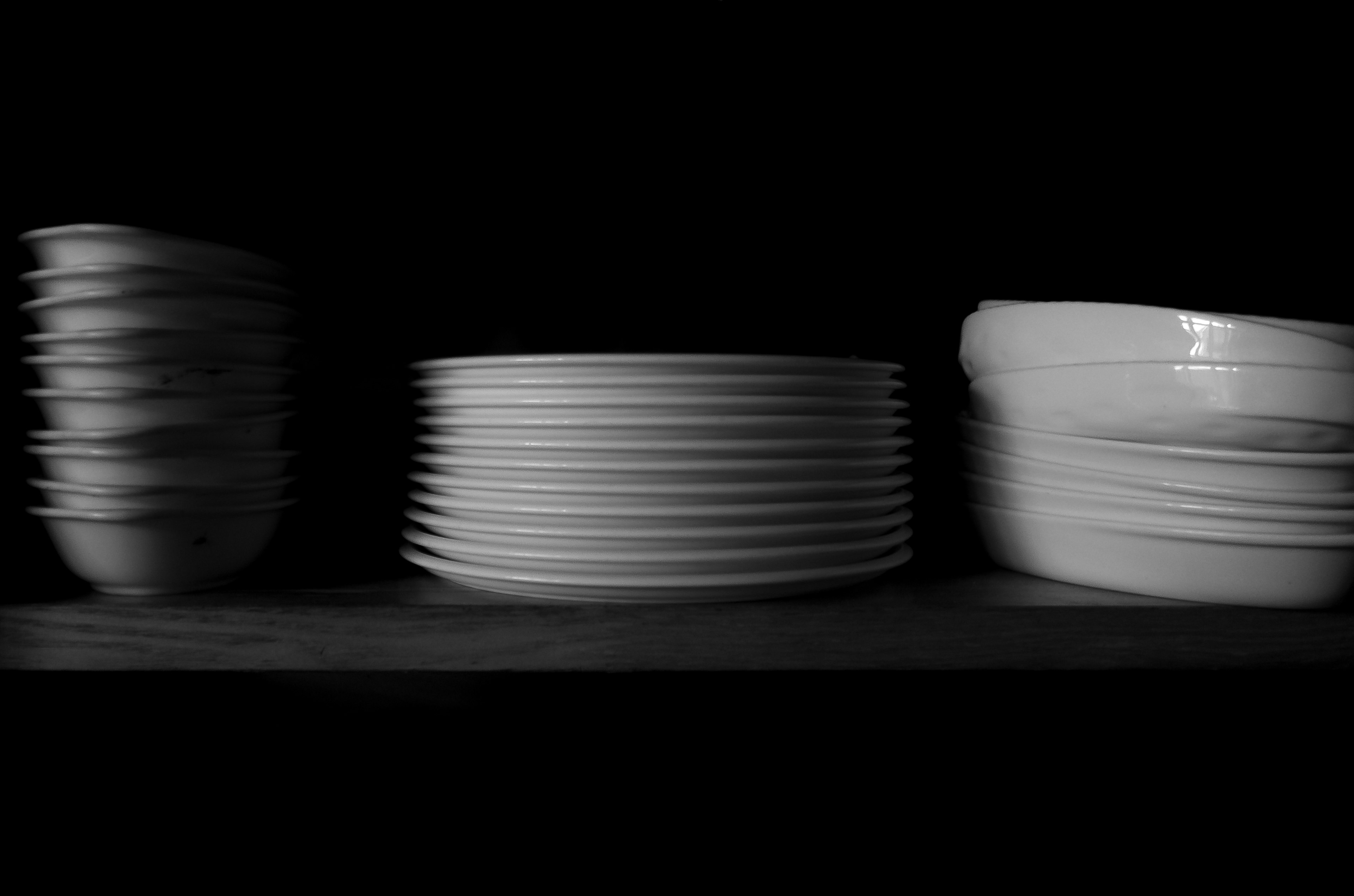 Simple arrangement of white plates against a black background