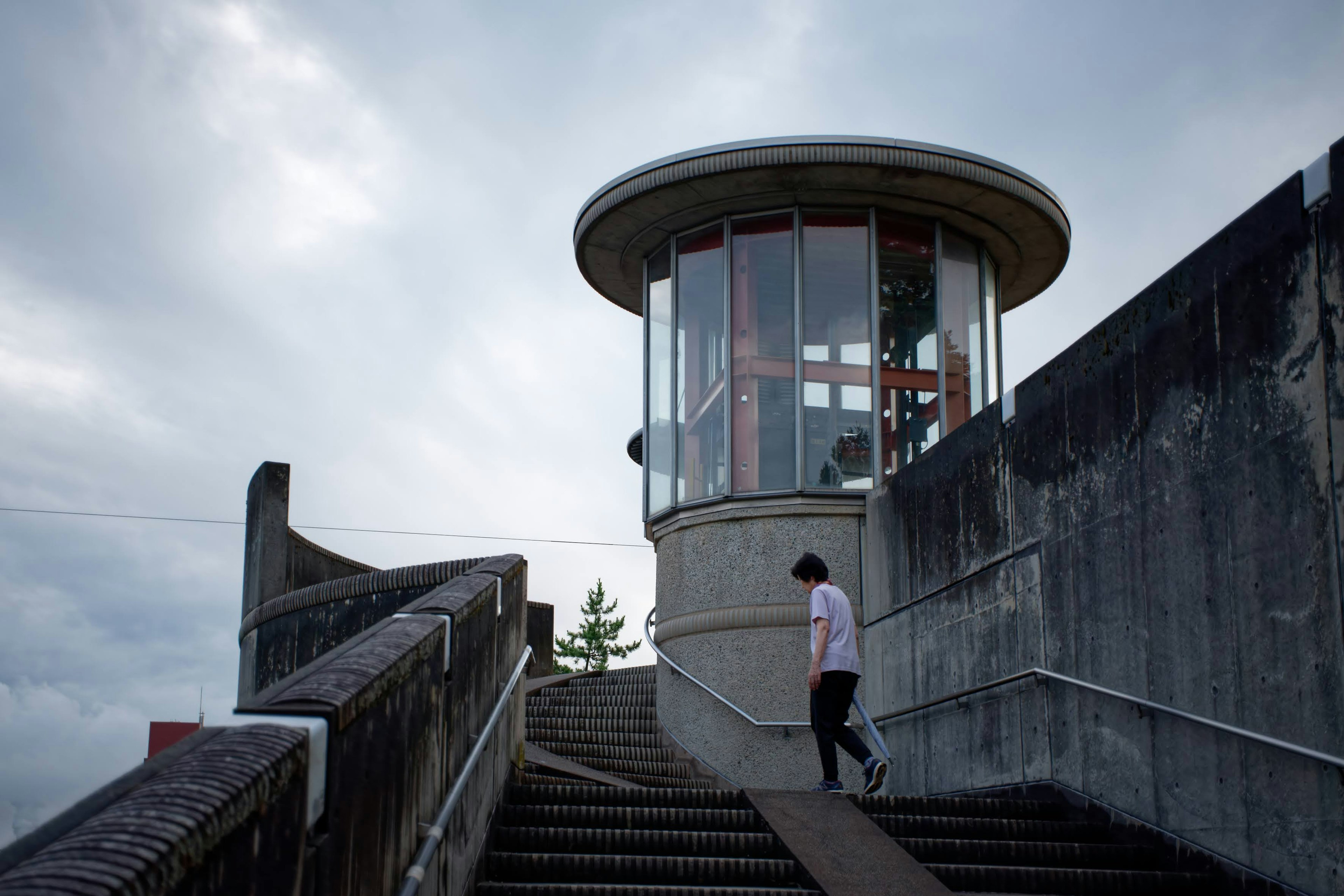 Person, die eine Treppe zu einem modernen Aussichtsturm hinaufgeht