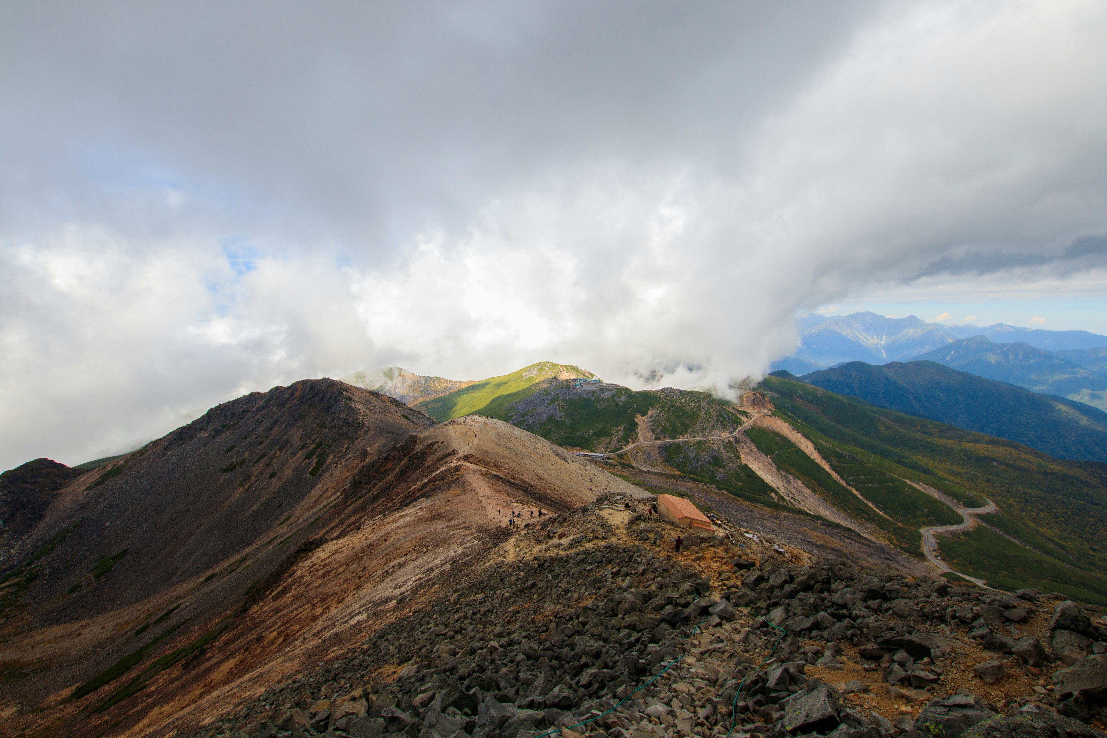 山地风景，阴云密布的天空和可见的绿草地