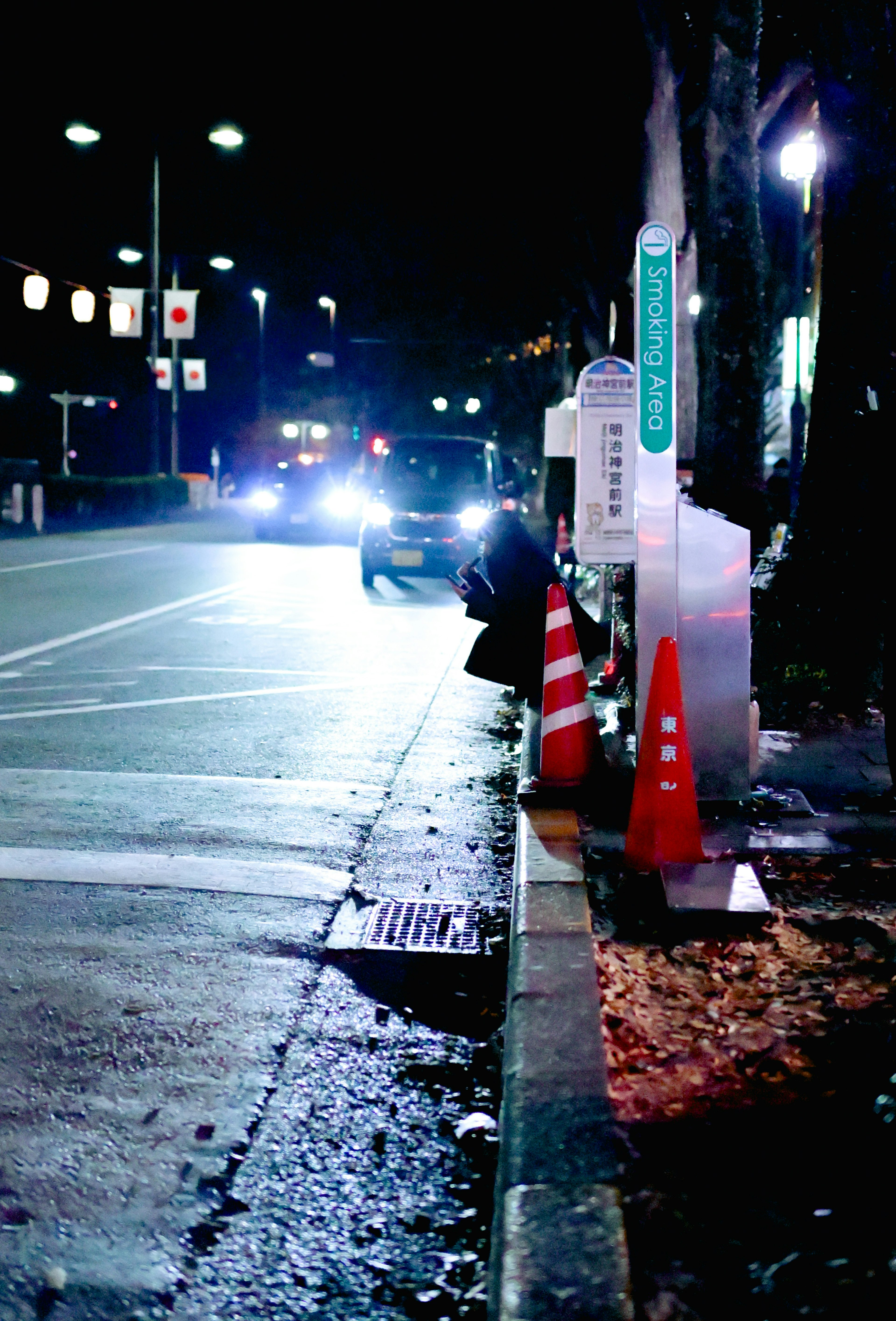 夜の街並みと車の光が映る交差点の風景