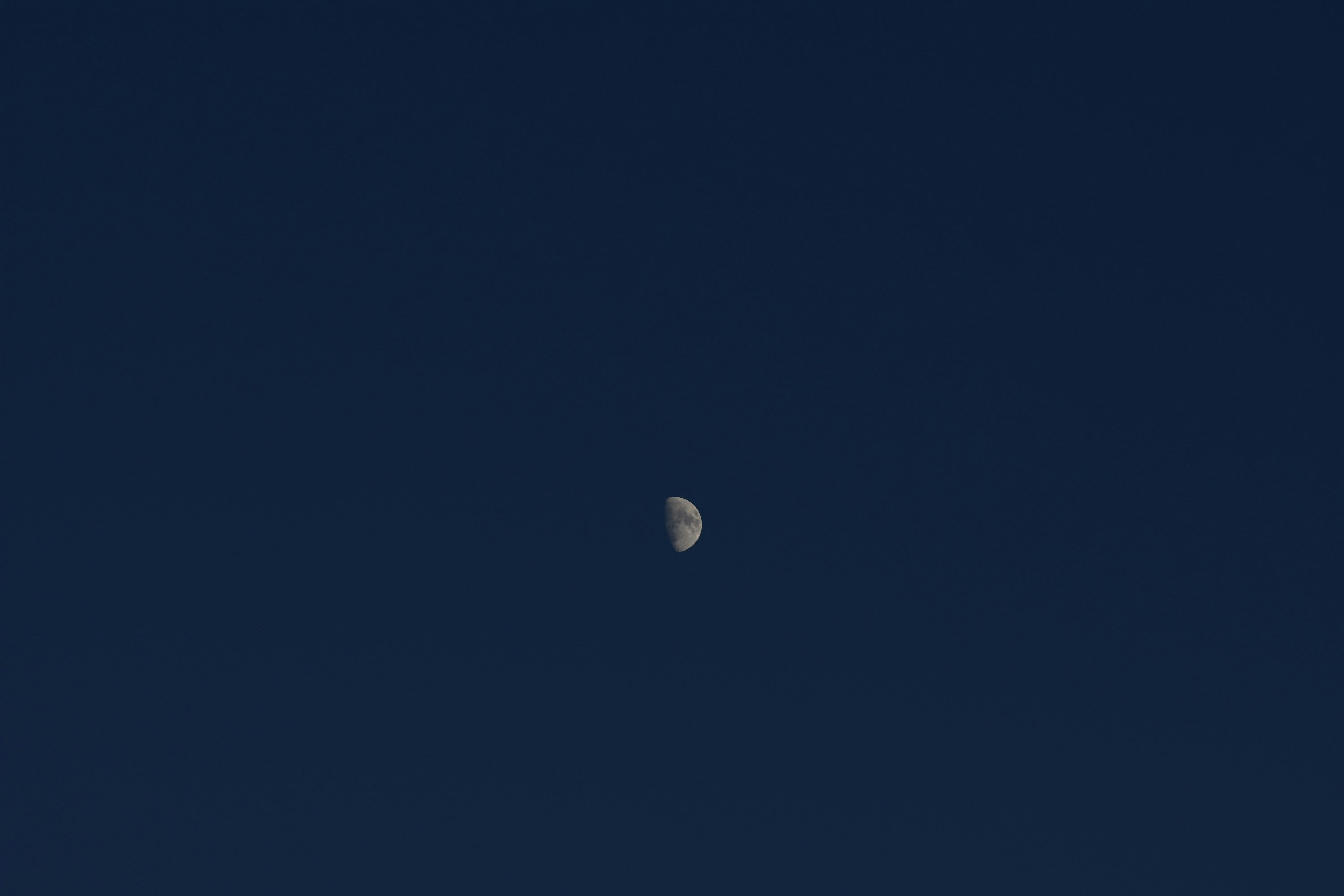 Luna en cuarto creciente en un cielo azul oscuro