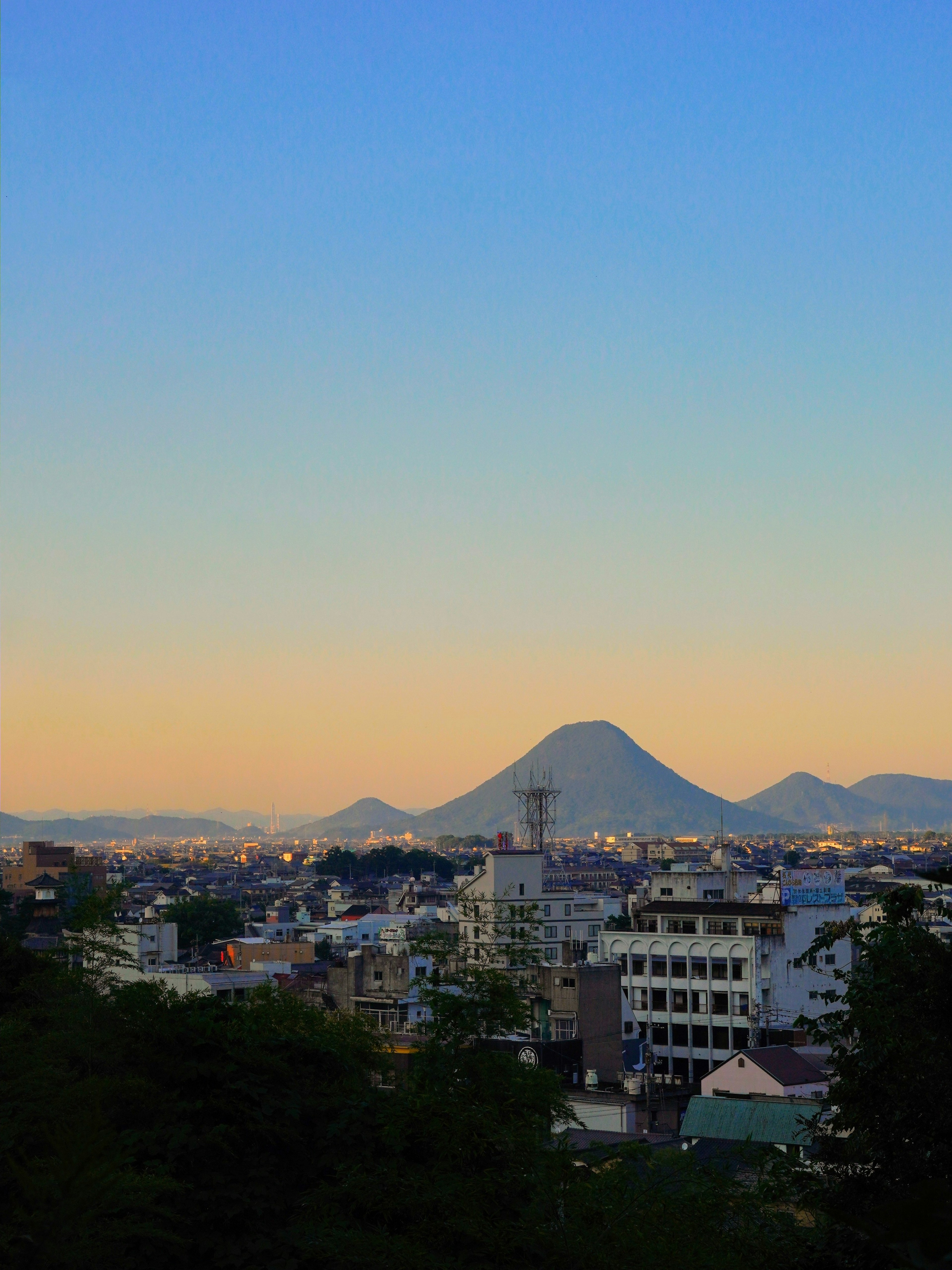 日落时的城市天际线和背景中的山