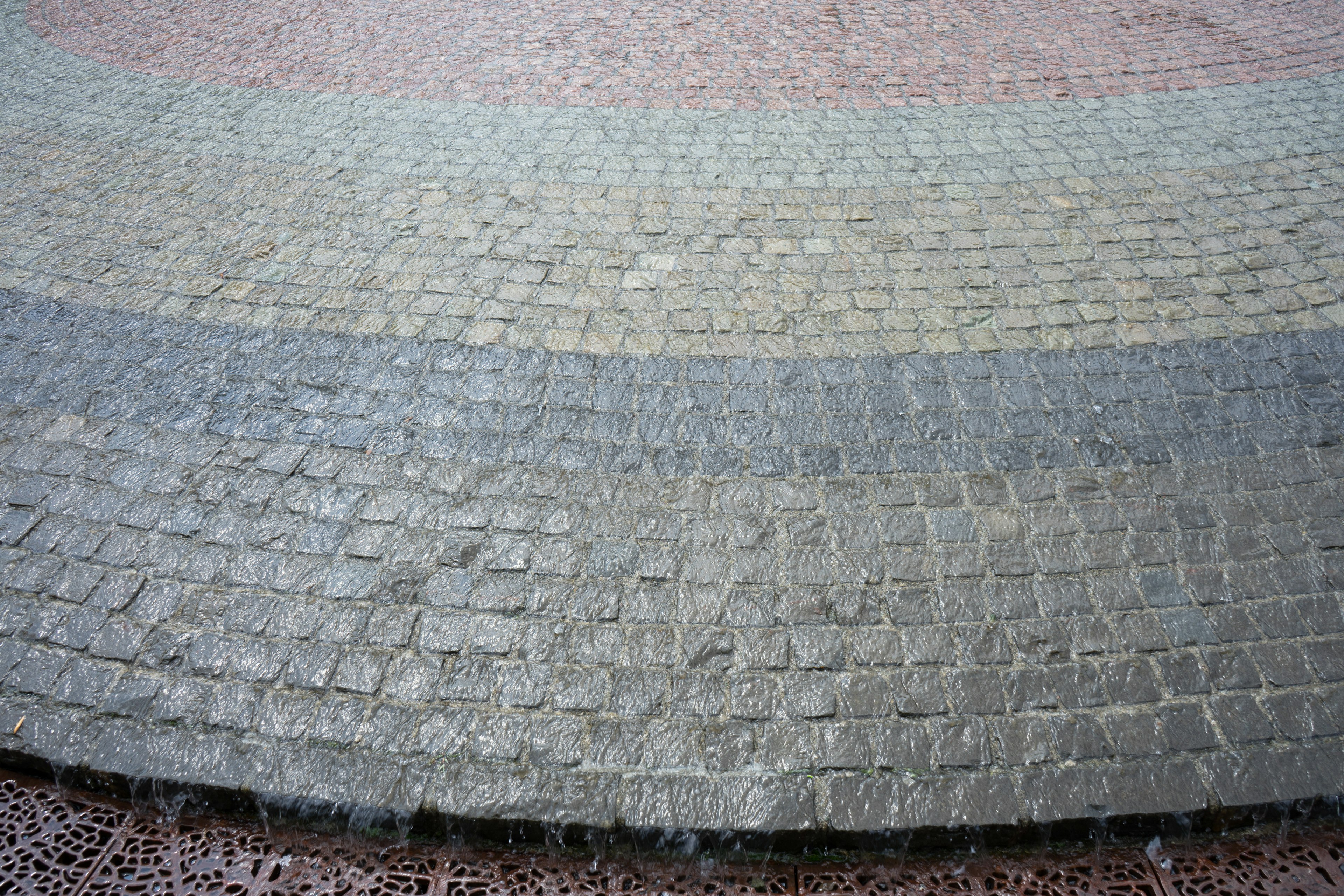 Imagen de una superficie pavimentada que muestra patrones de piedra curvados